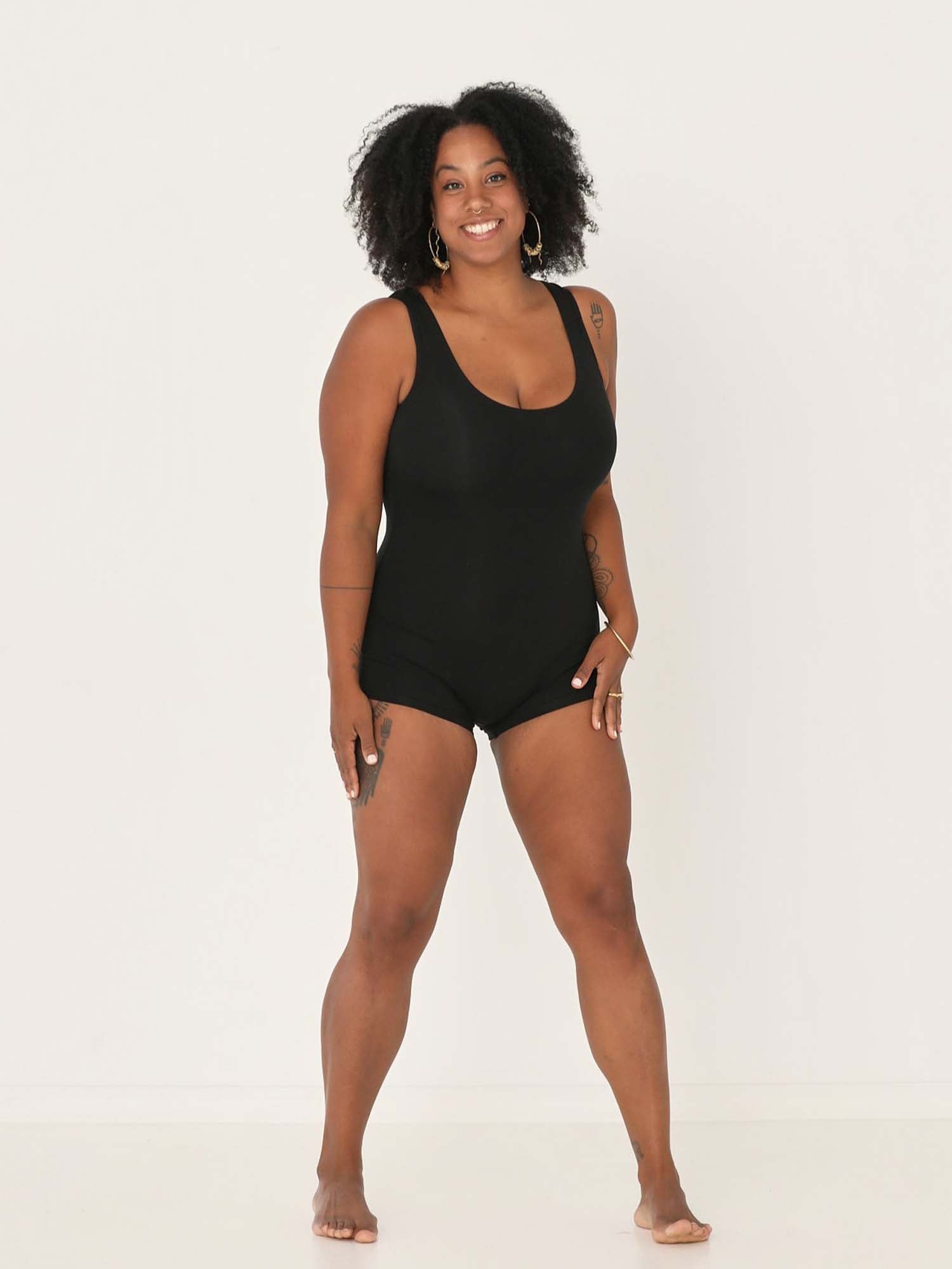 Model wearing a reversible black boyleg bodysuit with scoop and boat necklines, women's bamboo clothing