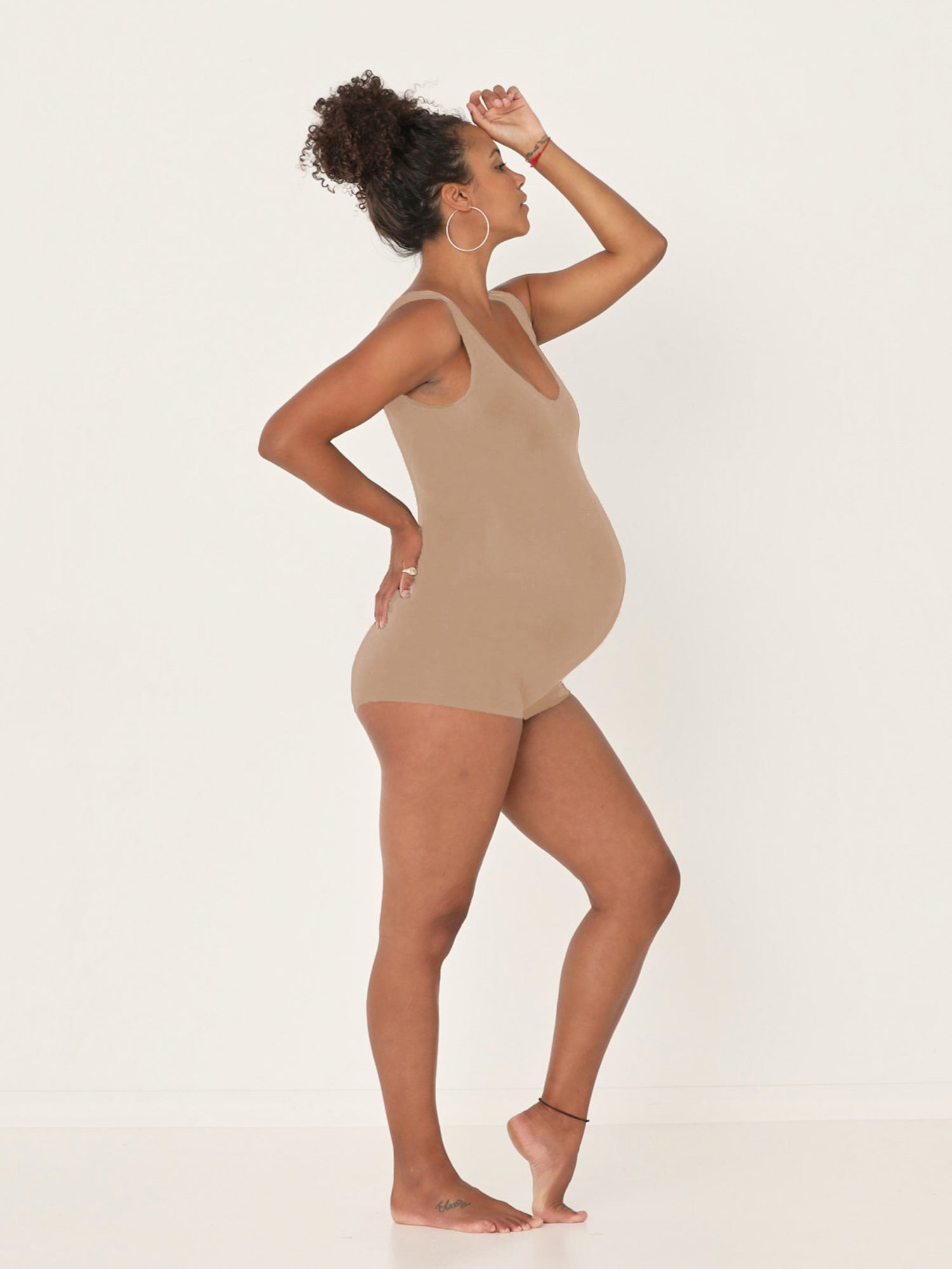 Model wearing a reversible caramel brown boyleg bodysuit with scoop and boat necklines, women's bamboo clothing
