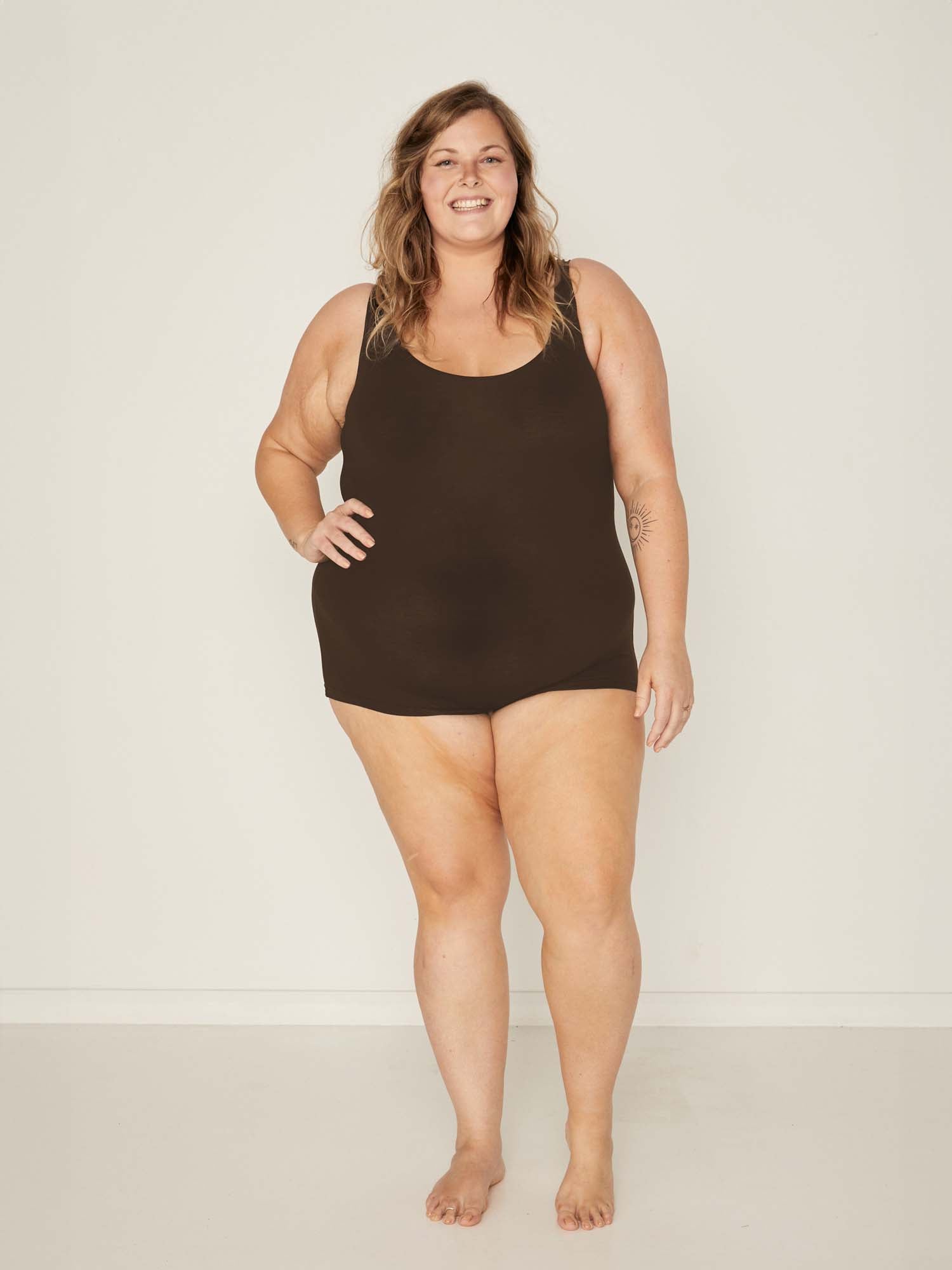 Model wearing a reversible cocoa brown boyleg bodysuit with scoop and boat necklines, women's bamboo clothing