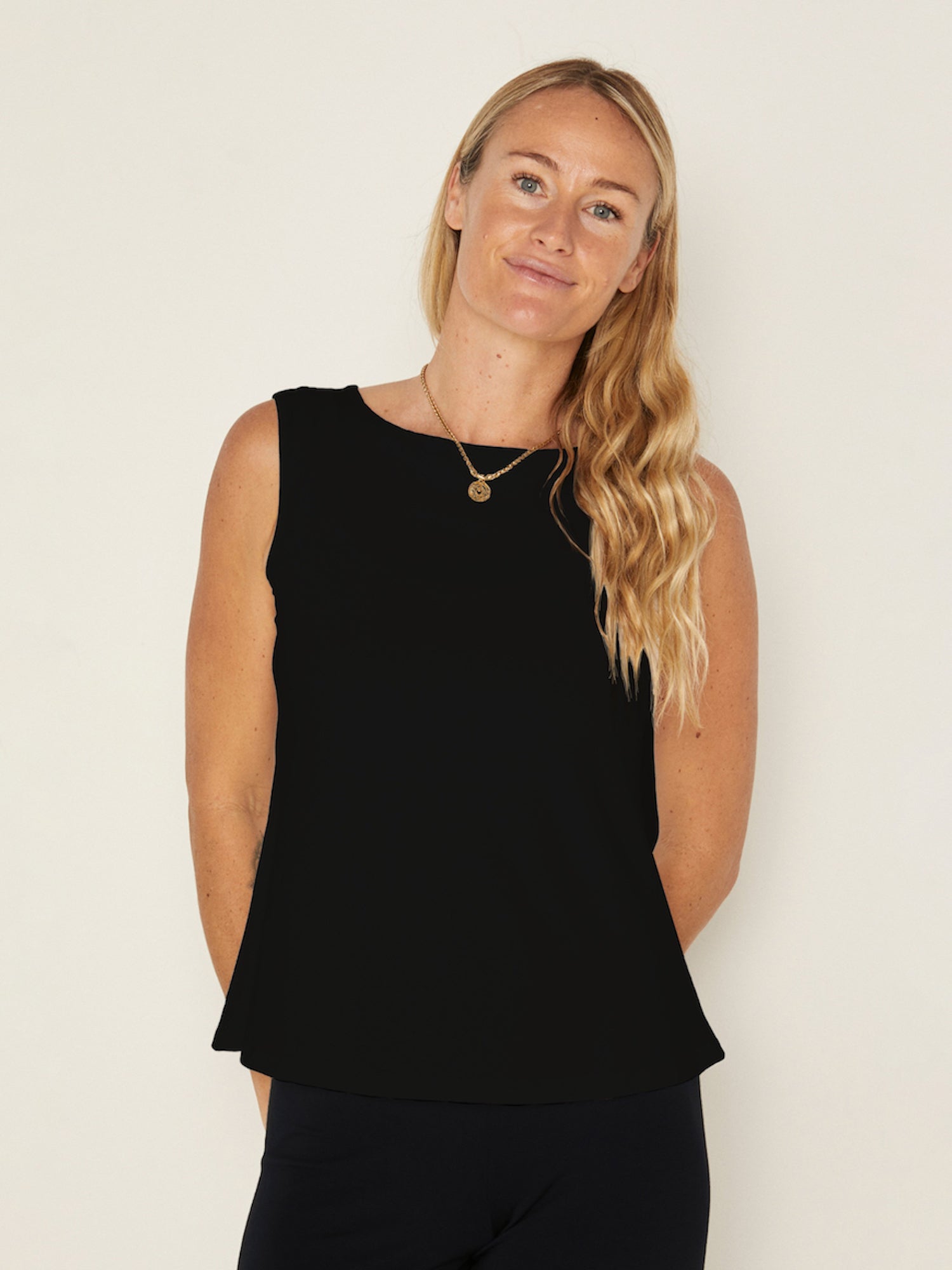 Model wearing a black boat neck singlet with wide shoulder coverage, women's bamboo clothing