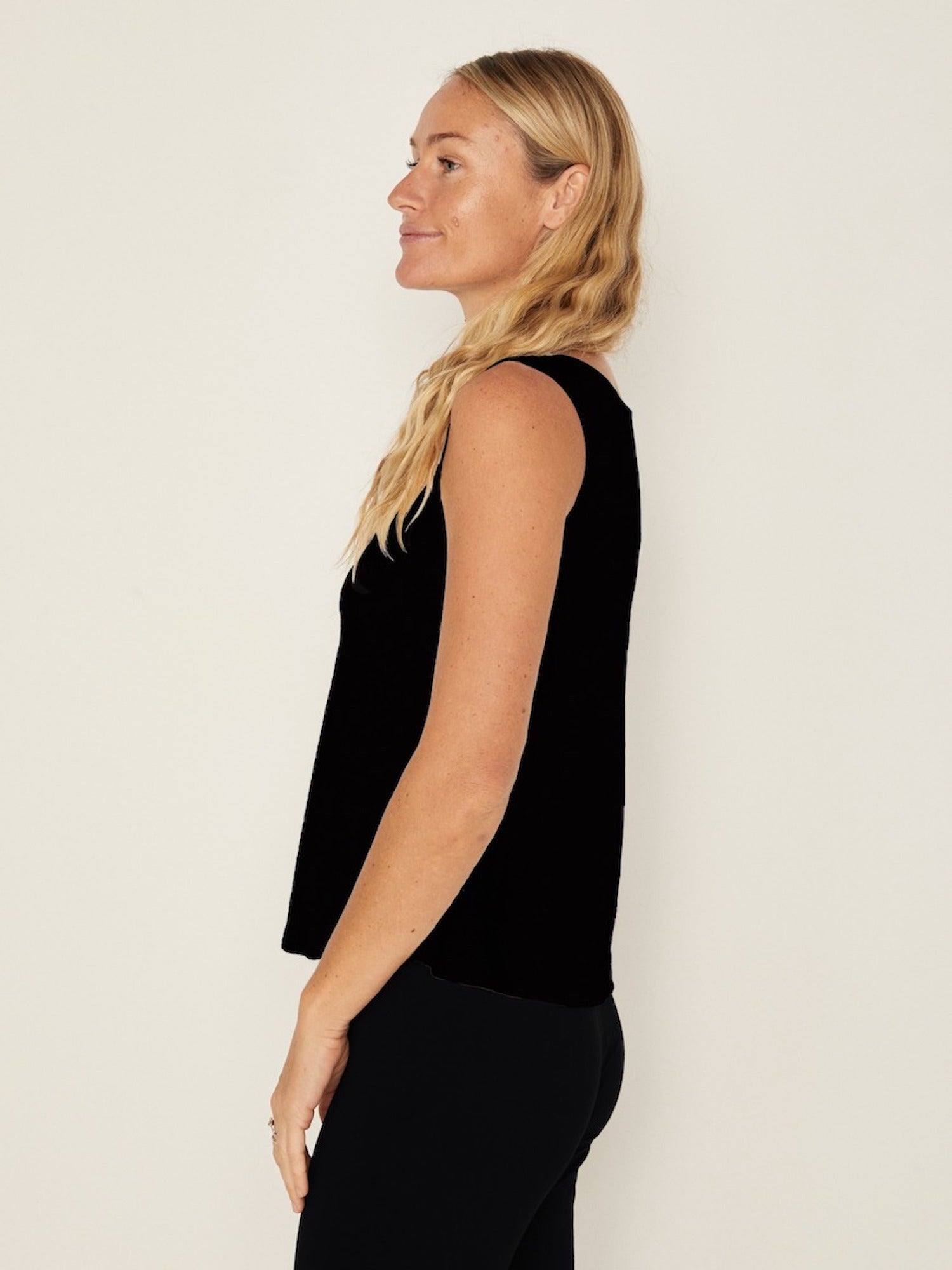 Model wearing a black boat neck singlet with wide shoulder coverage, women's bamboo clothing