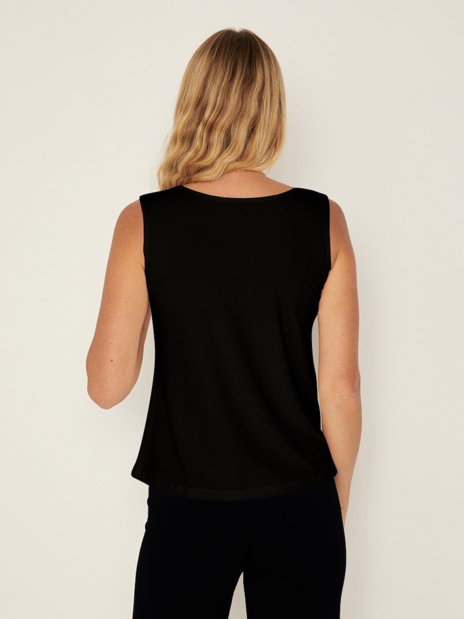 Model wearing a black boat neck singlet with wide shoulder coverage, women's bamboo clothing