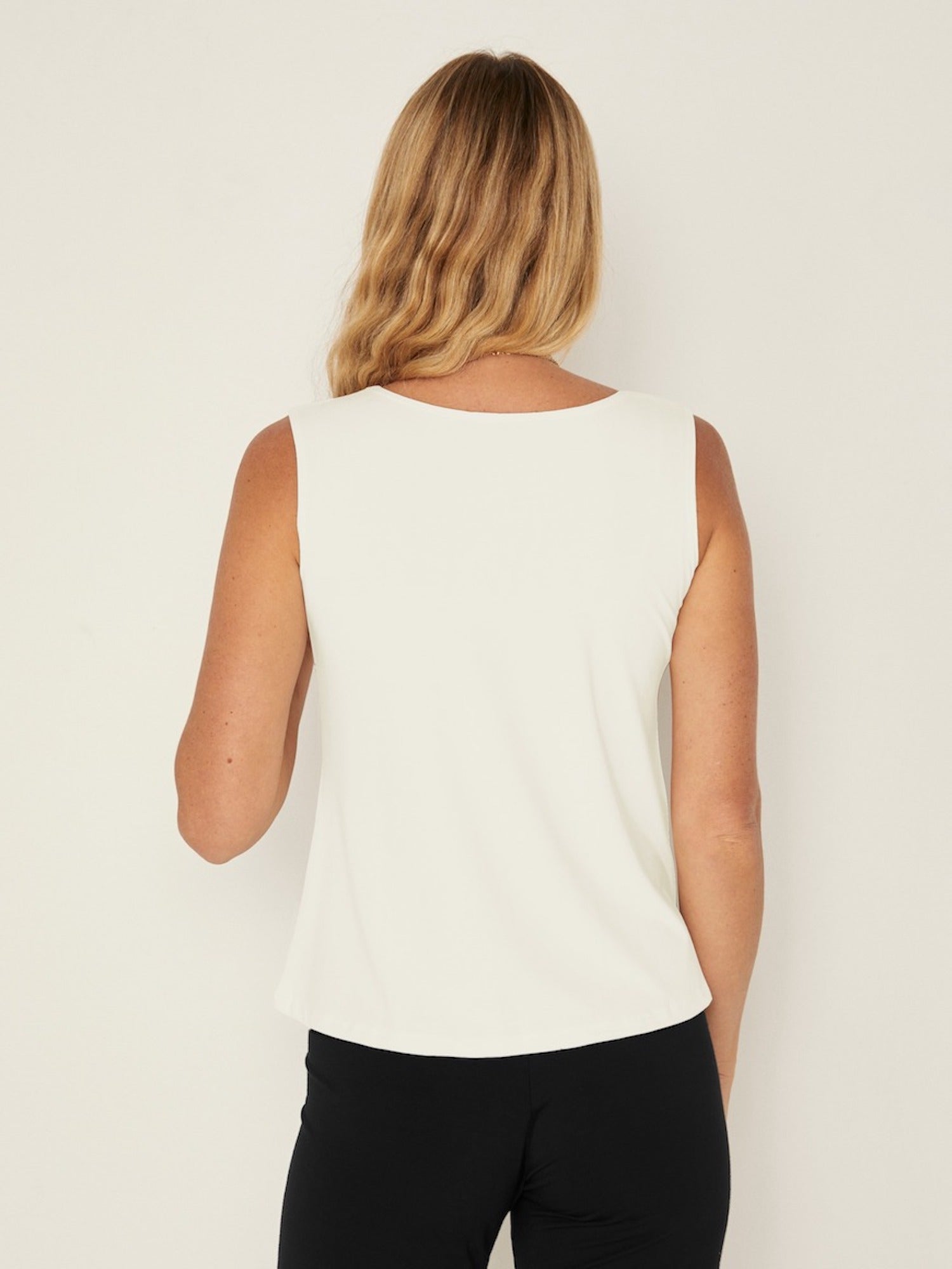 Model wearing a cream boat neck singlet with wide shoulder coverage, women's bamboo clothing