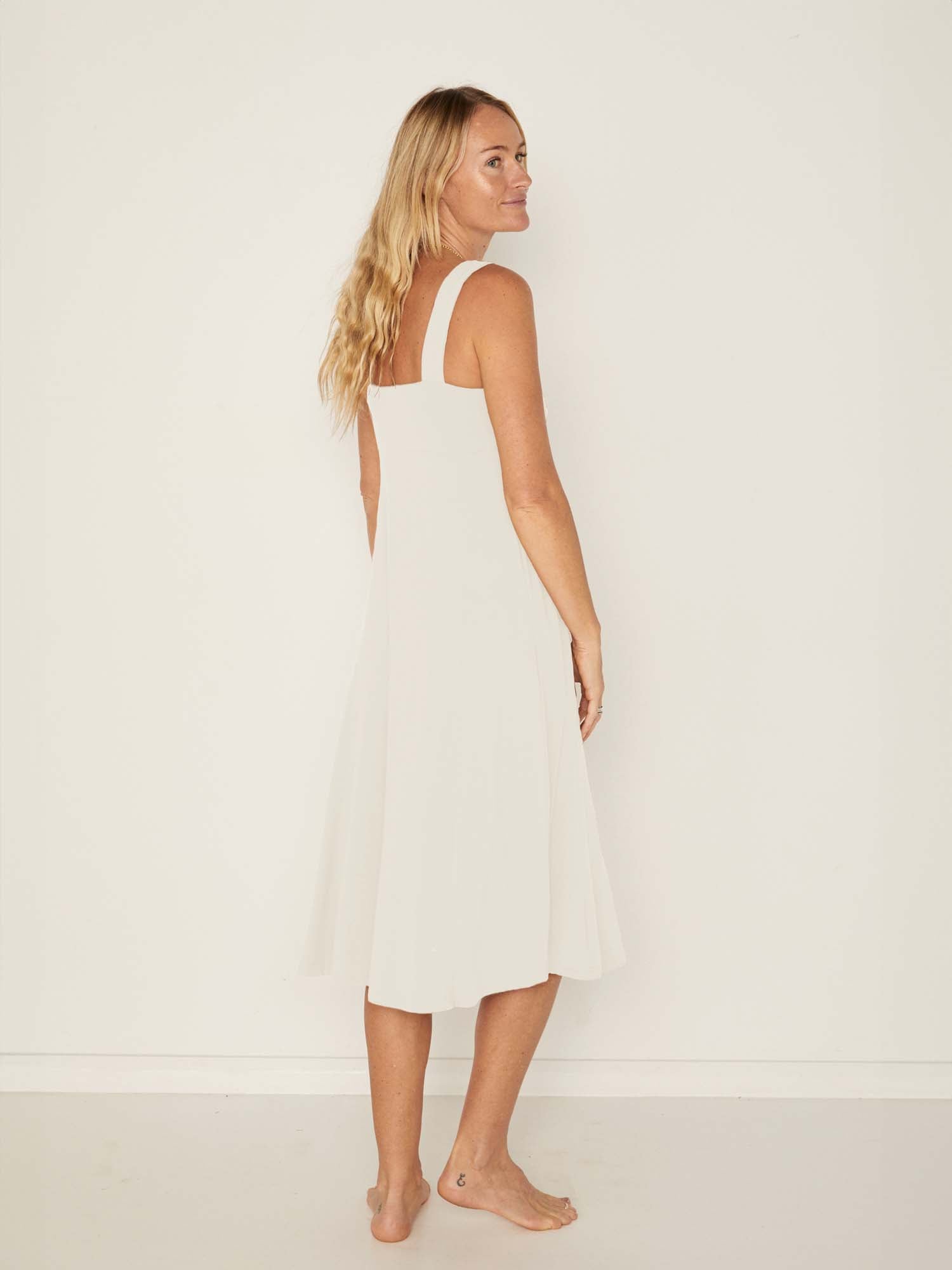 Model wearing a cream mid length, sweetheart neckline swing style dress, women's bamboo clothing