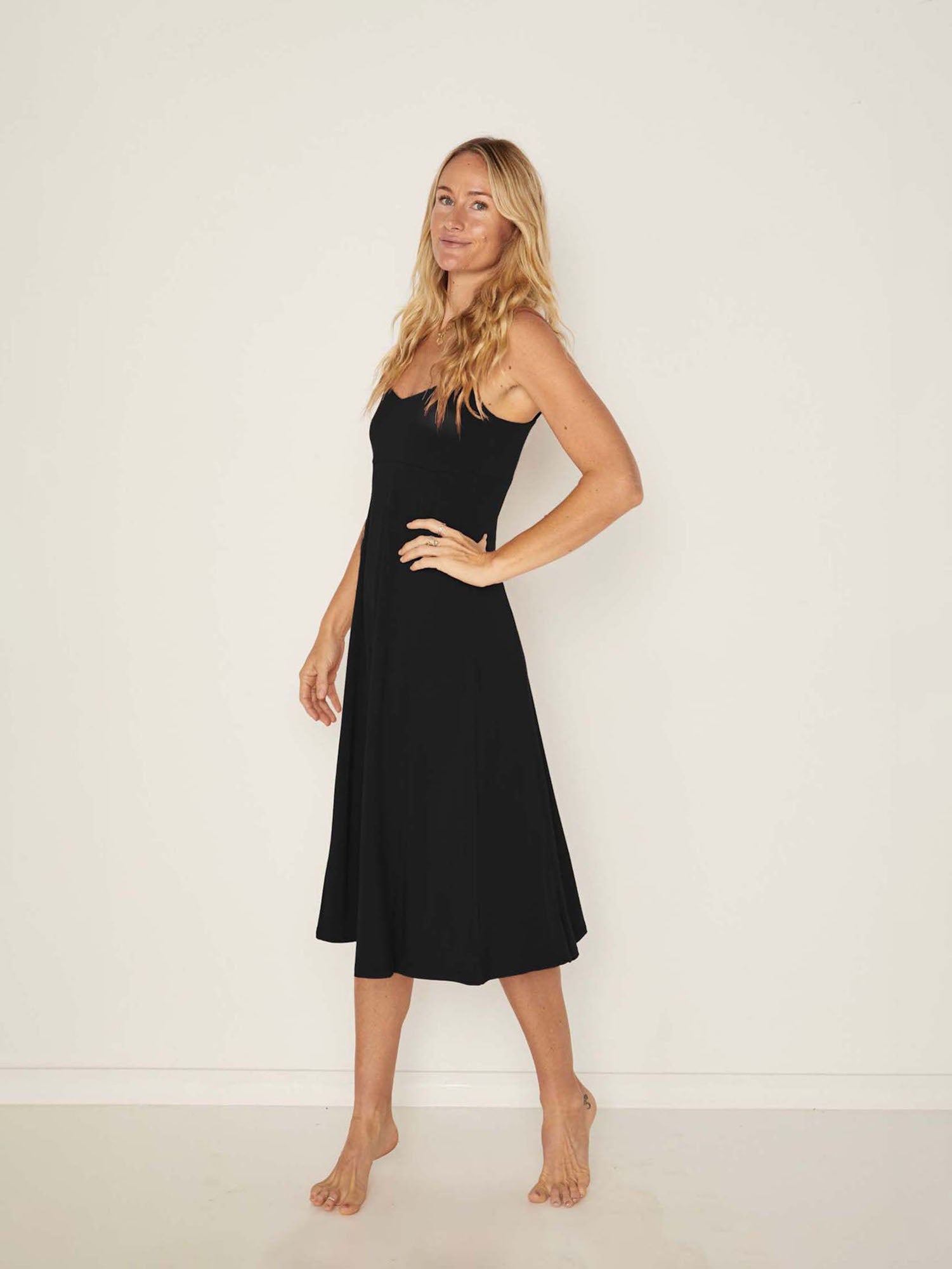 Model wearing a black mid length, sweetheart neckline swing style dress, women's bamboo clothing
