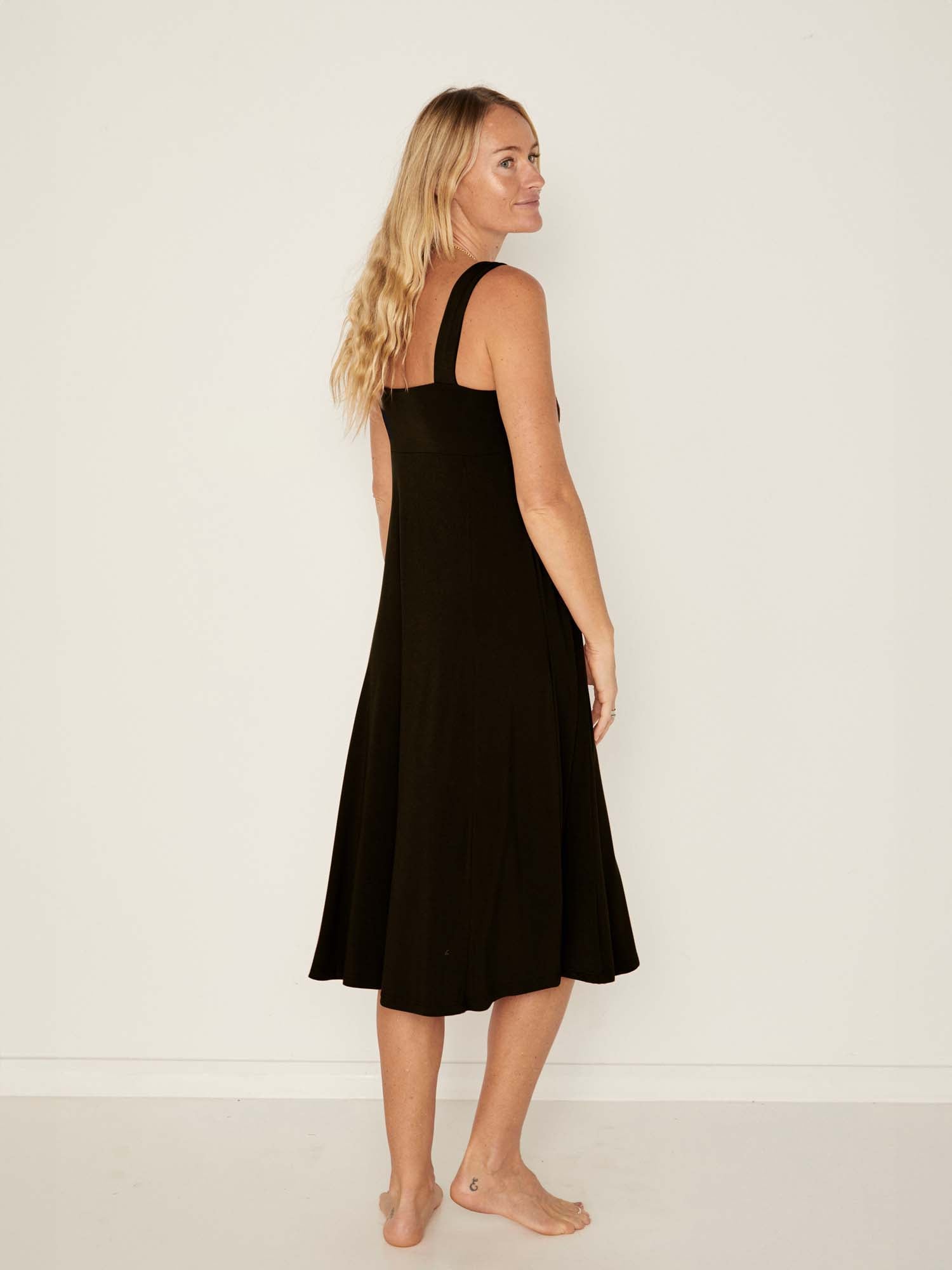 Model wearing a black mid length, sweetheart neckline swing style dress, women's bamboo clothing