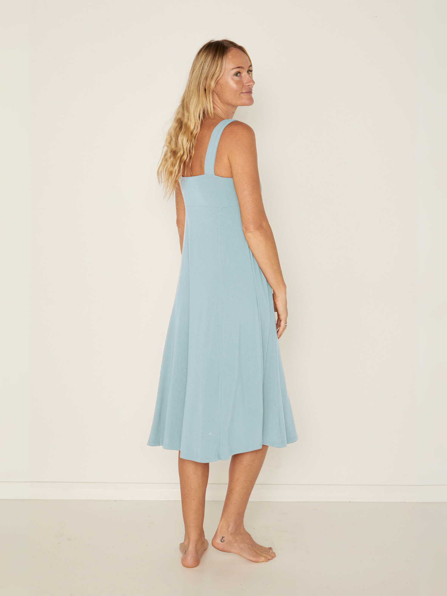 Woman wearing a light blue dress against a white background