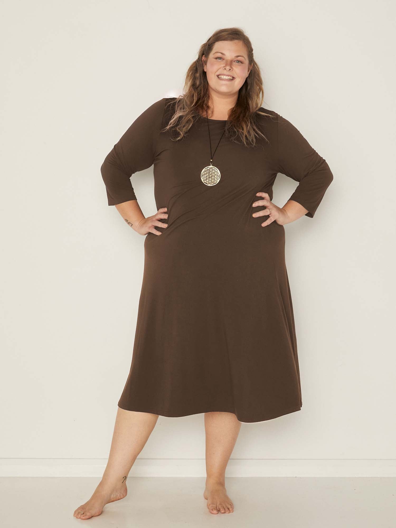 Model wearing a cocoa brown mid sleeve 3/4 dress with a scoop neckline and generous swing in body, women's bamboo clothing