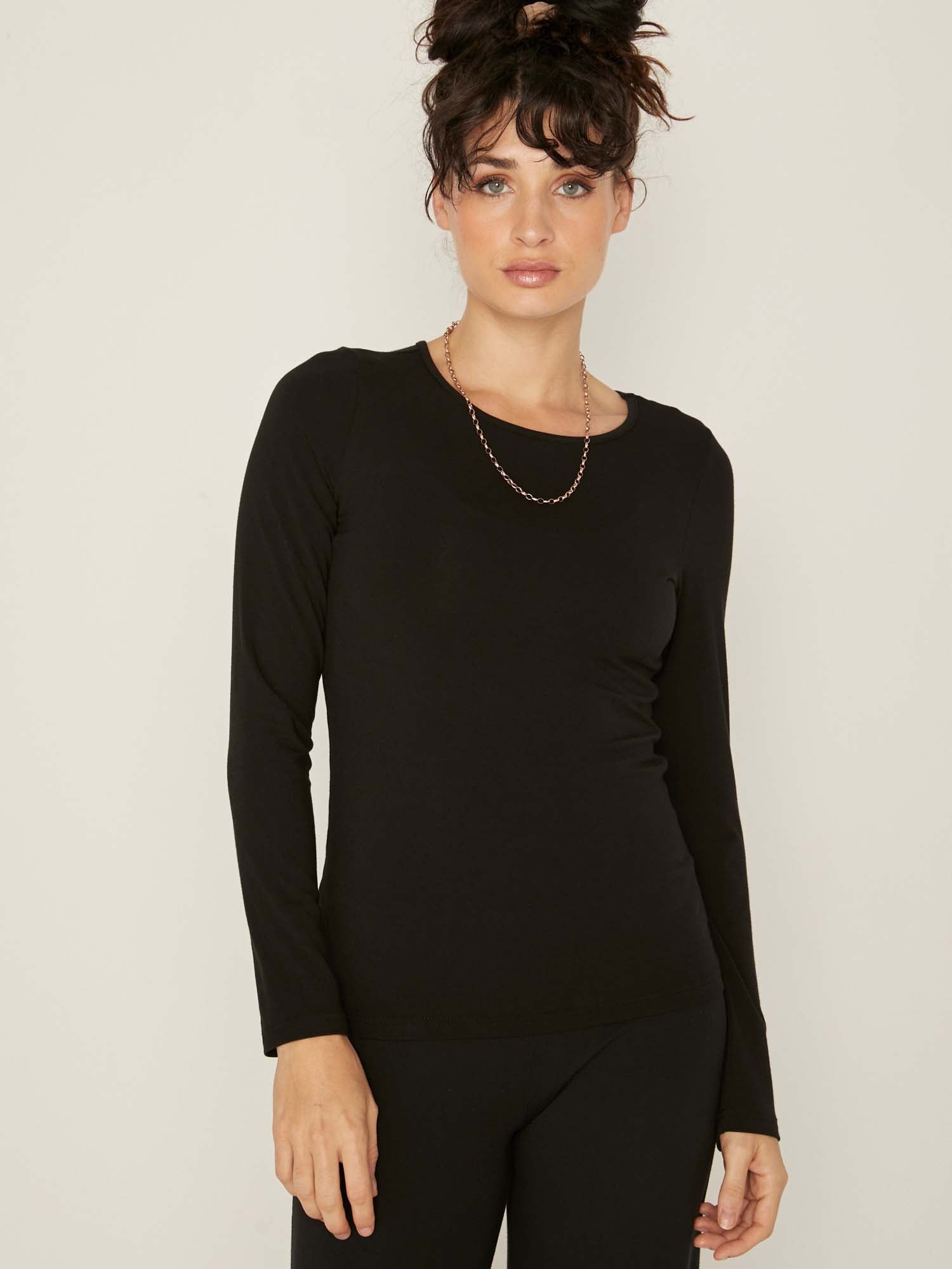 Model wearing a reversible black fitted body long sleeve t-shirt with crew and boat necklines, women's bamboo clothing