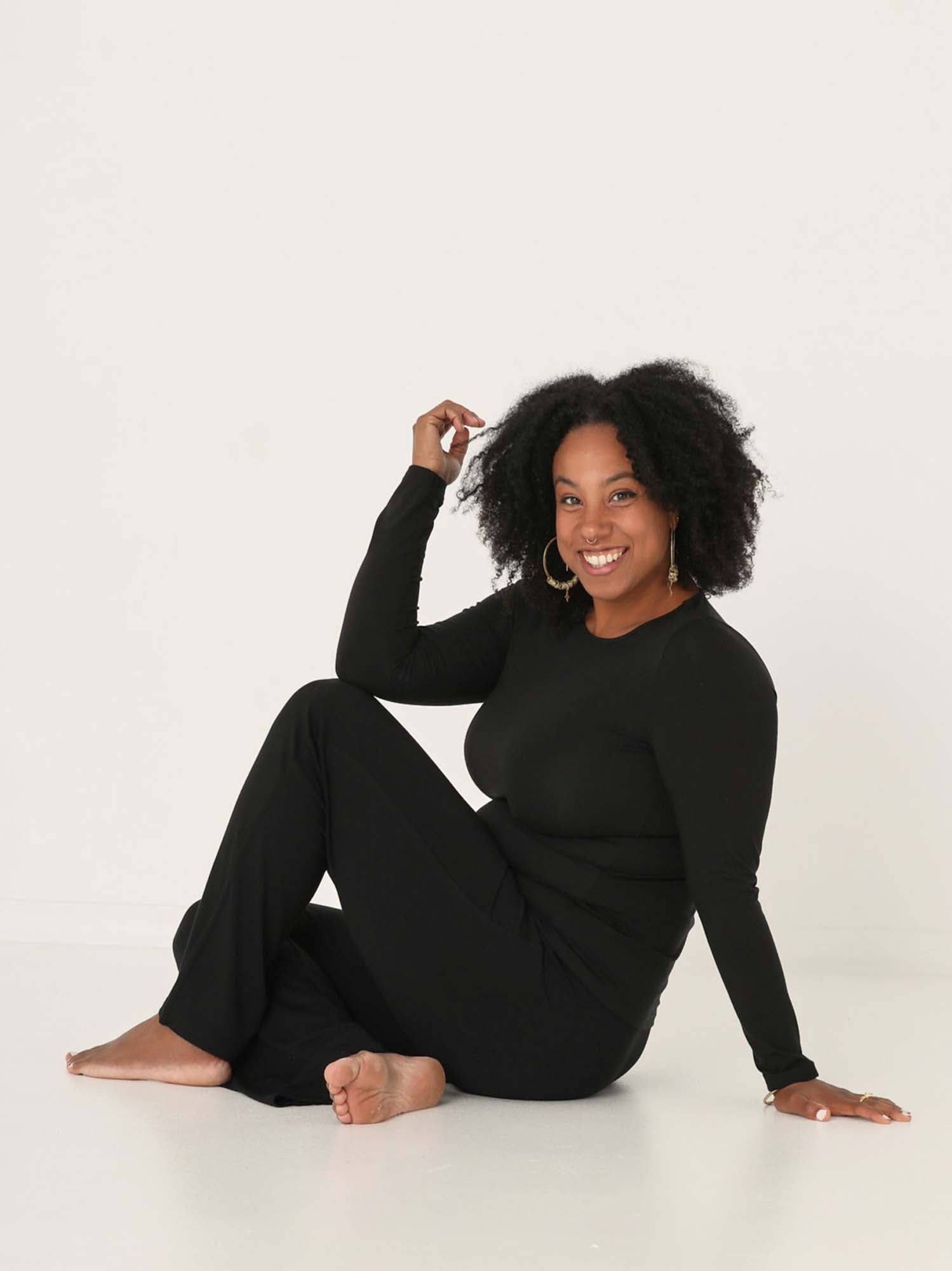 Model wearing a reversible black fitted body long sleeve t-shirt with crew and boat necklines, women's bamboo clothing