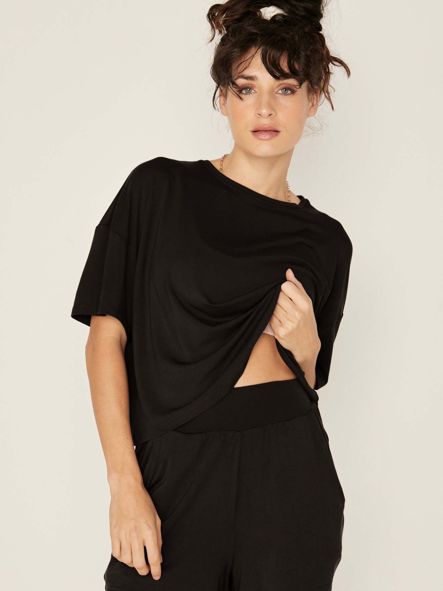 Model wearing a black cropped boxy t-shirt, crew neckline, relaxed short sleeve and drop shoulder, women's bamboo clothing