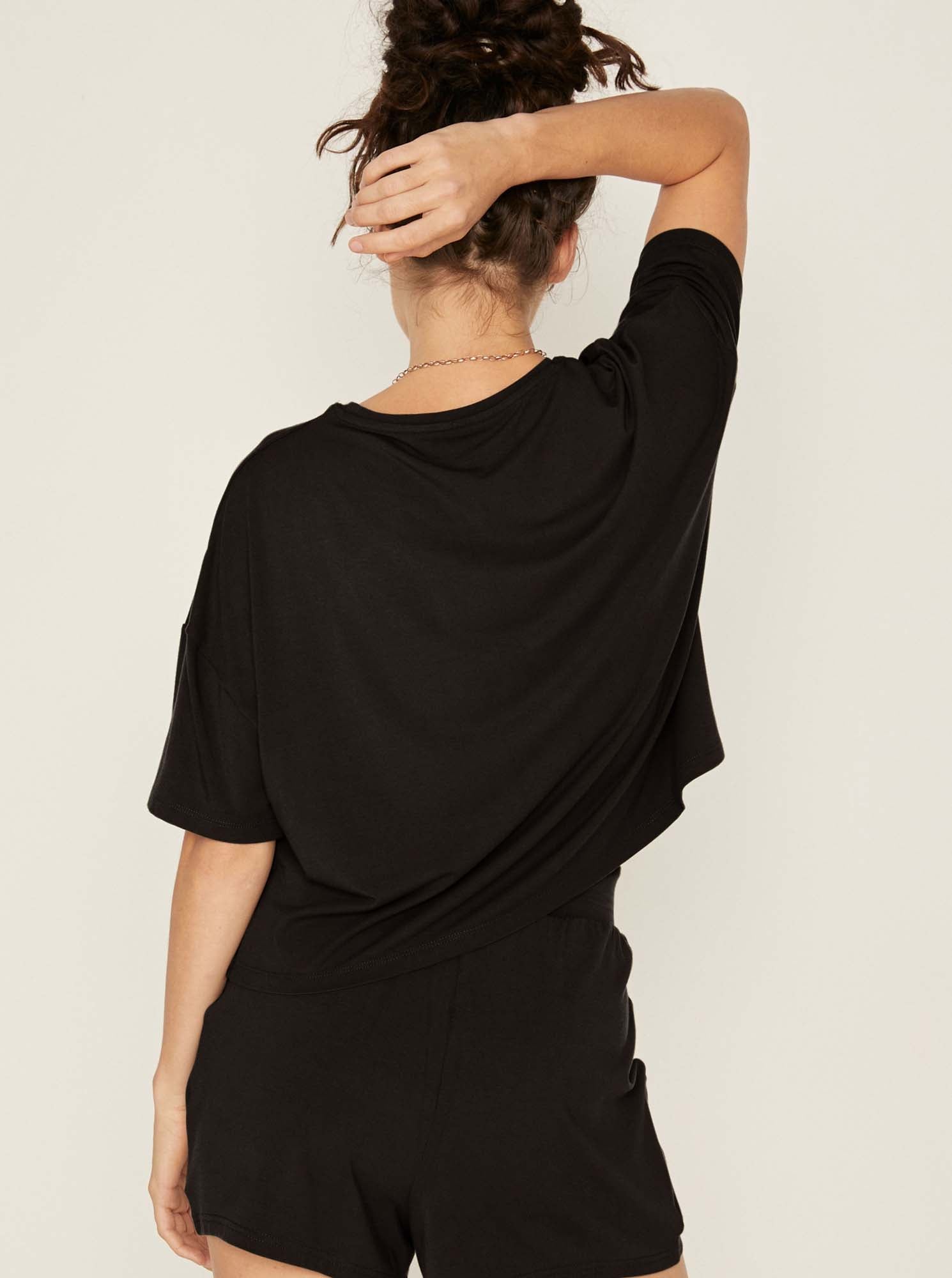 Model wearing a black cropped boxy t-shirt, crew neckline, relaxed short sleeve and drop shoulder, women's bamboo clothing