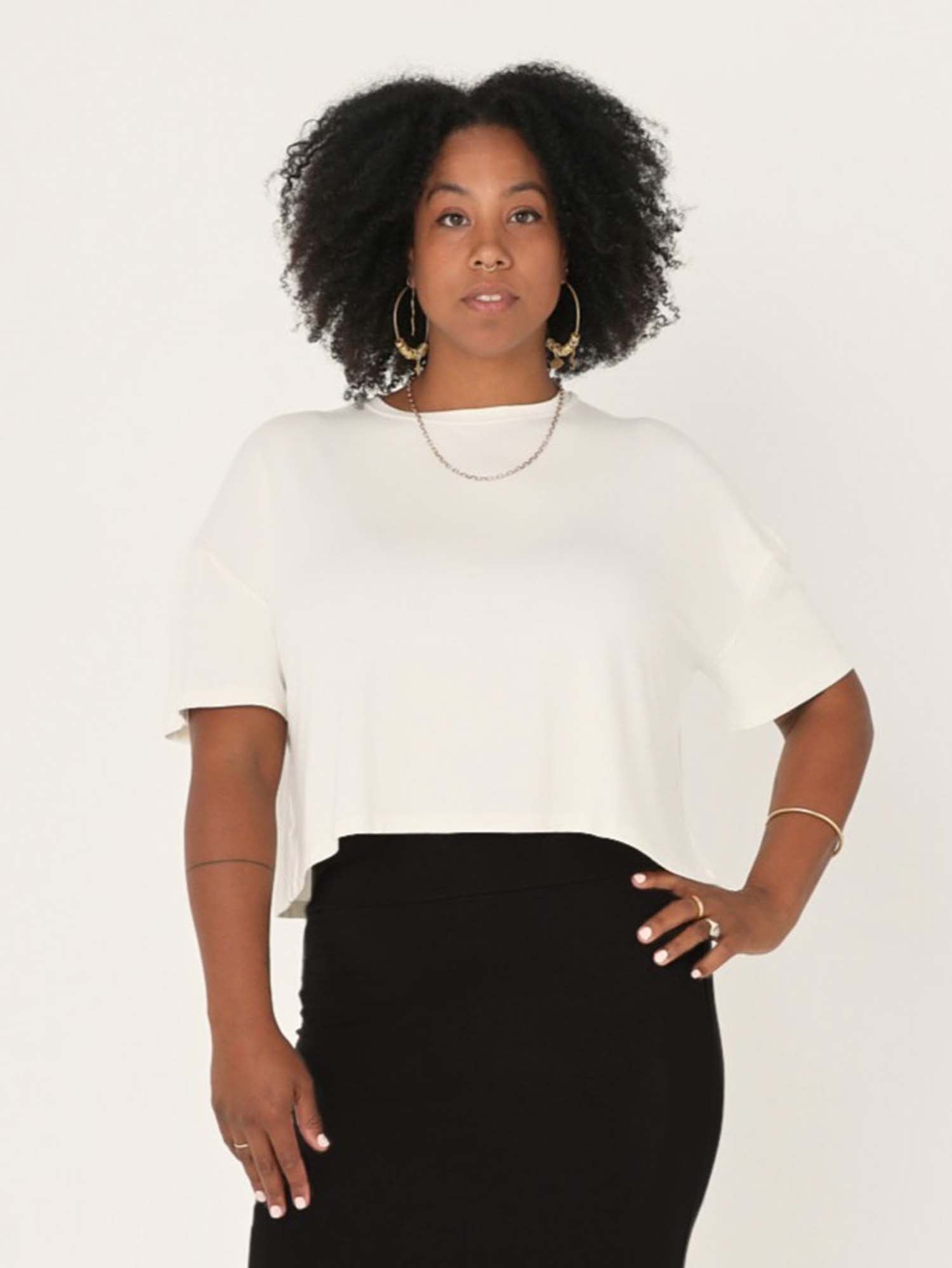 Model wearing a cream cropped boxy t-shirt, crew neckline, relaxed short sleeve and drop shoulder, women's bamboo clothing