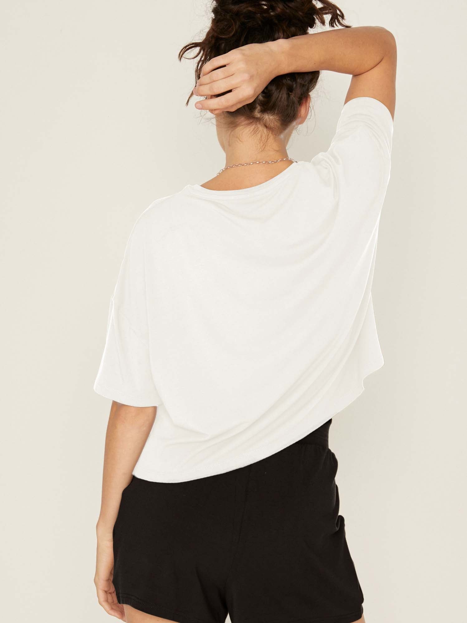 Model wearing a cream cropped boxy t-shirt, crew neckline, relaxed short sleeve and drop shoulder, women's bamboo clothing