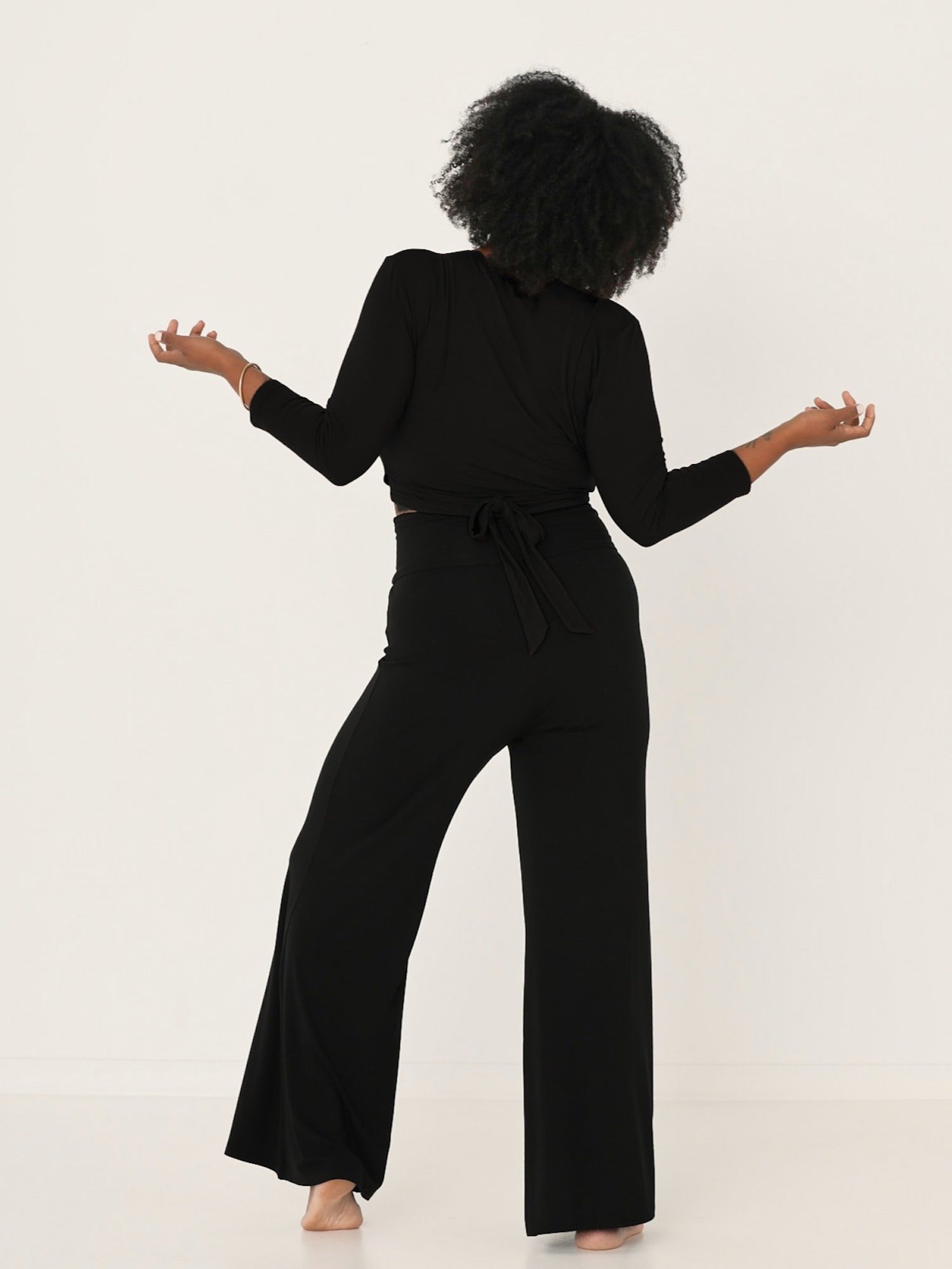Model wearing a black ballet wrap cardigan with plunge neckline and fitted 3/4 sleeves, women's bamboo clothing