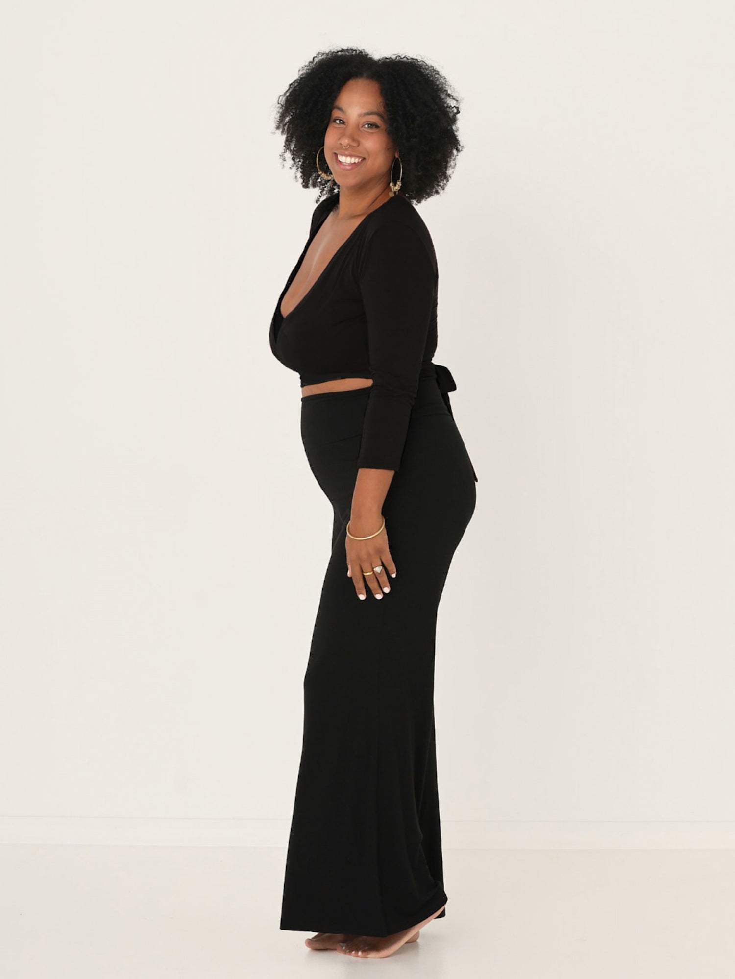 Model wearing a black ballet wrap cardigan with plunge neckline and fitted 3/4 sleeves, women's bamboo clothing