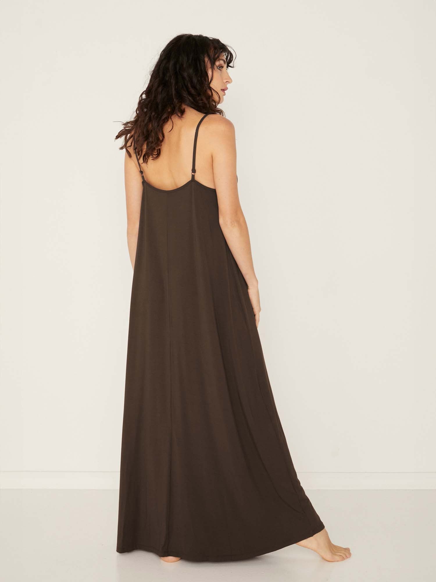 Model wearing a cocoa brown swing maxi dress with a scoop neck and elasticated camisole straps, women's bamboo clothing