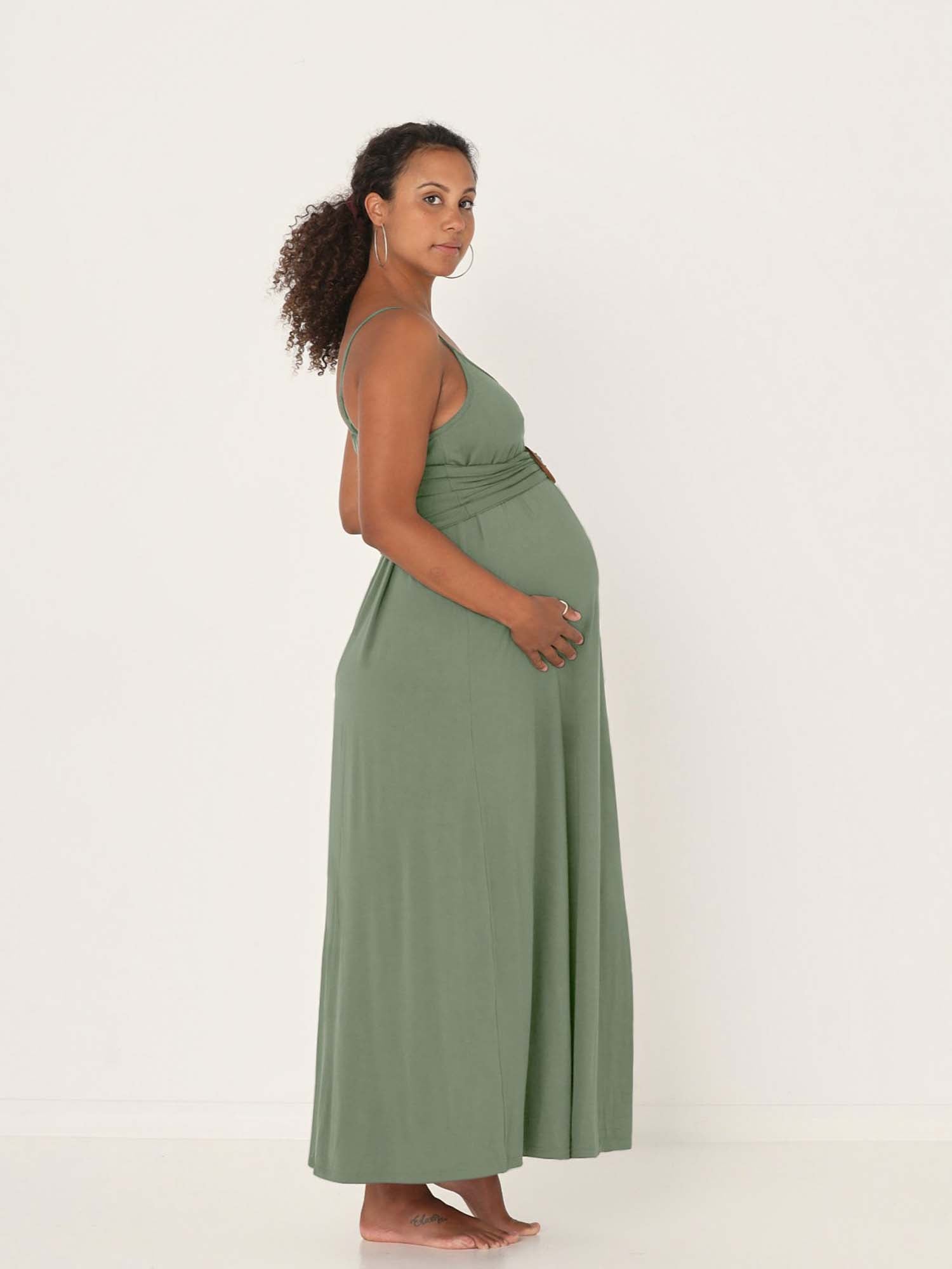 Model wearing a eucalyptus green swing maxi dress with a scoop neck and elasticated camisole straps, women's bamboo clothing