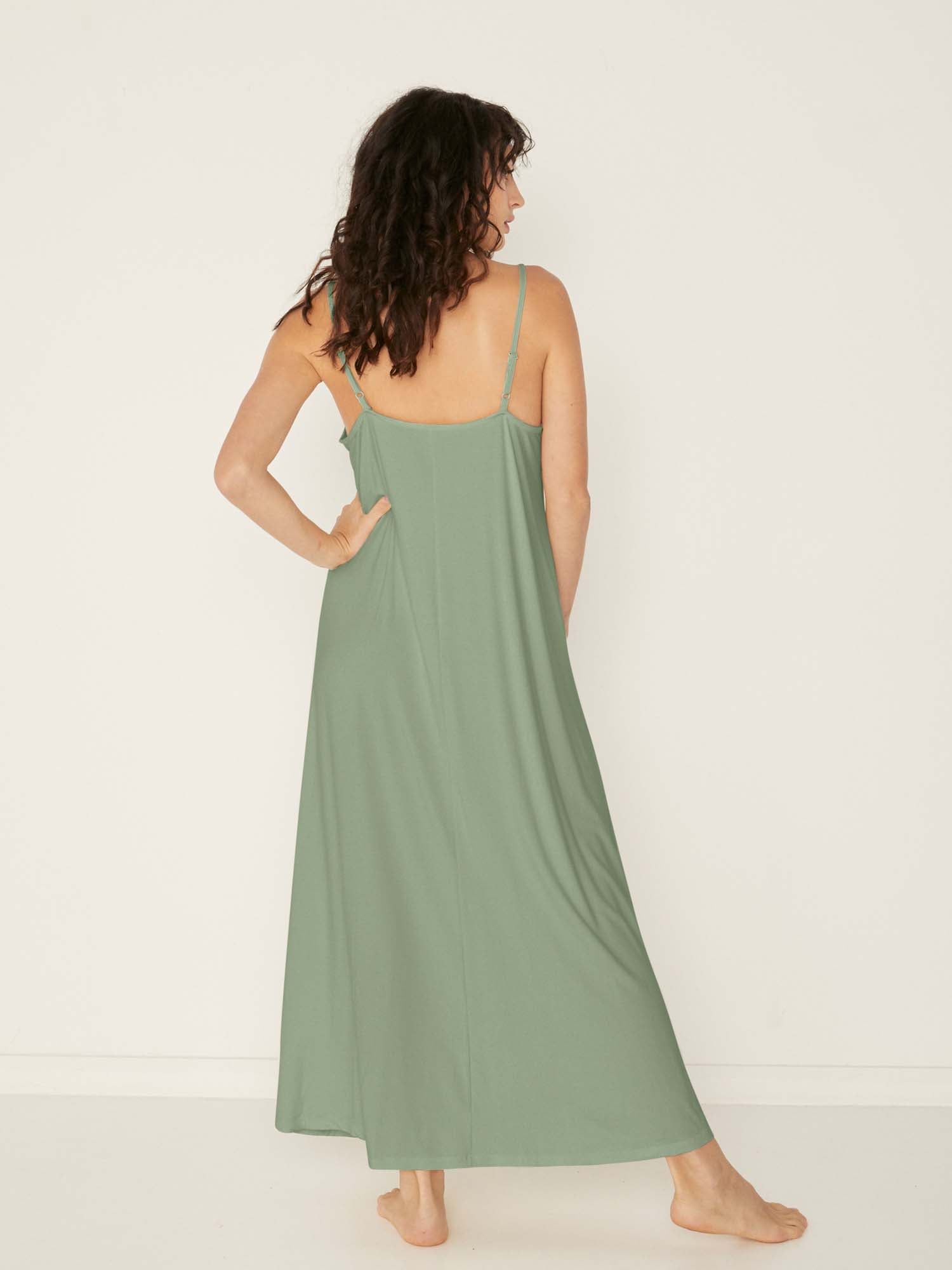 Model wearing a eucalyptus green swing maxi dress with a scoop neck and elasticated camisole straps, women's bamboo clothing