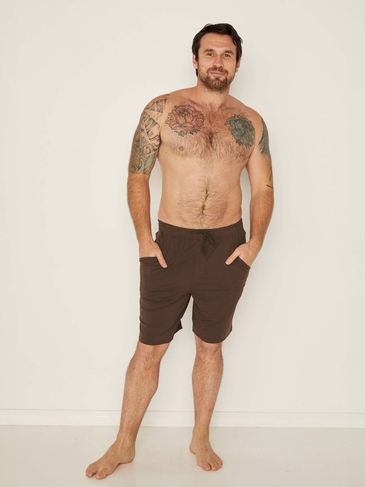 Male model wearing knee length cocoa brown casual shorts with elasticised waist and deep pockets, men's bamboo clothing