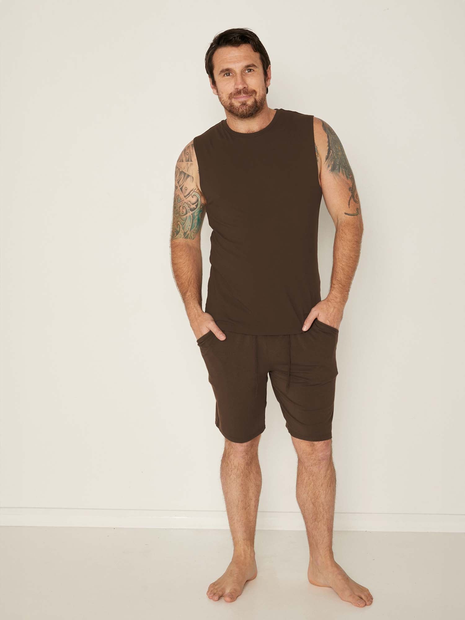 Male model wearing knee length cocoa brown casual shorts with elasticised waist and deep pockets, men's bamboo clothing