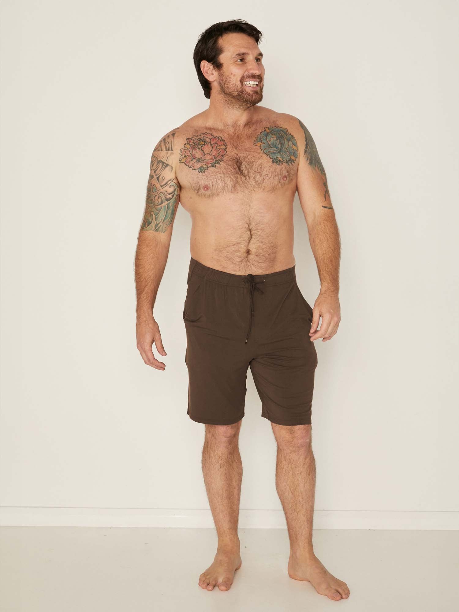 Male model wearing knee length cocoa brown casual shorts with elasticised waist and deep pockets, men's bamboo clothing