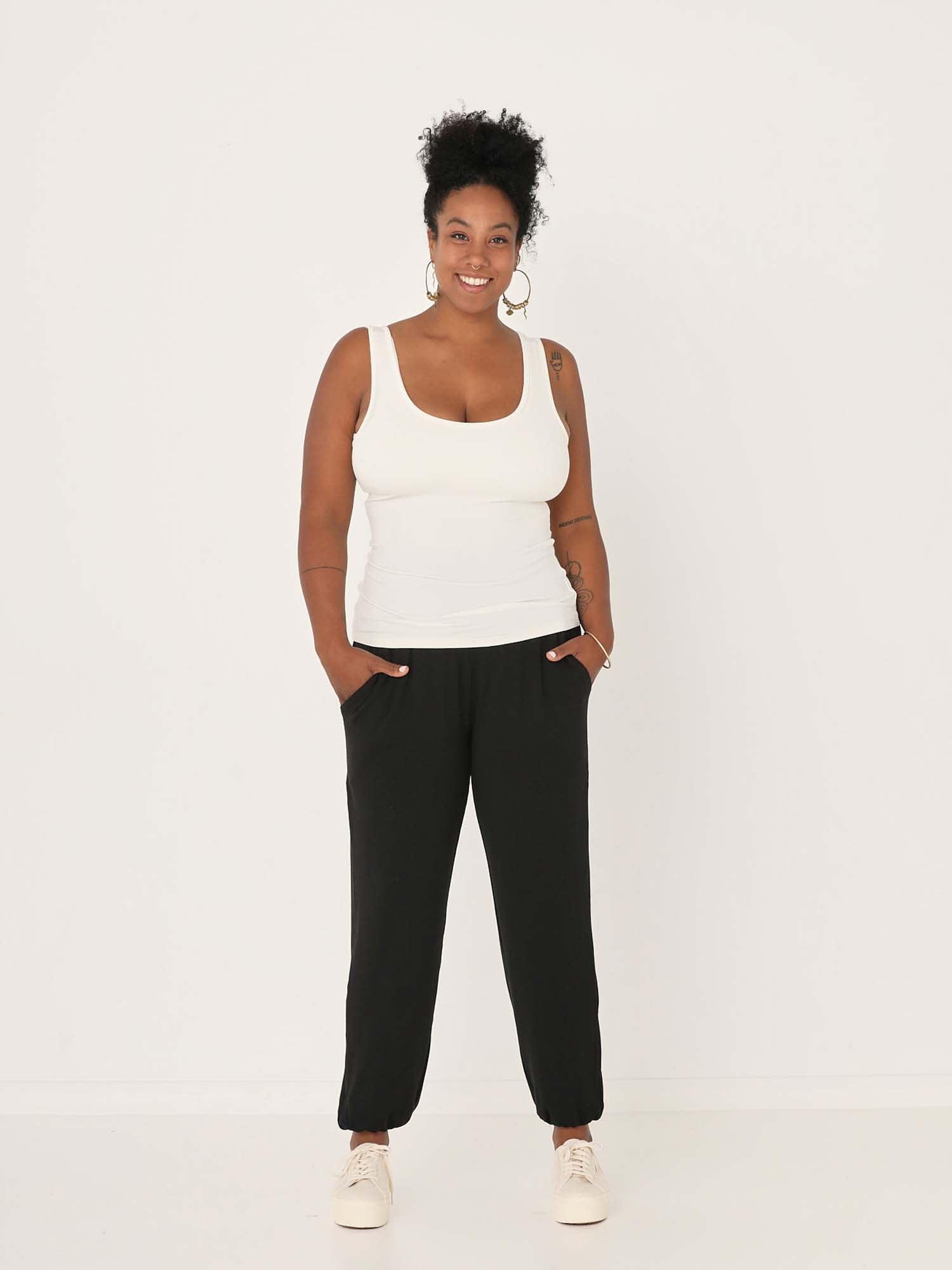 Model wearing black lounge pants with a deep waistband, long relaxed leg, elasticised cuff and side pockets, women's bamboo clothing