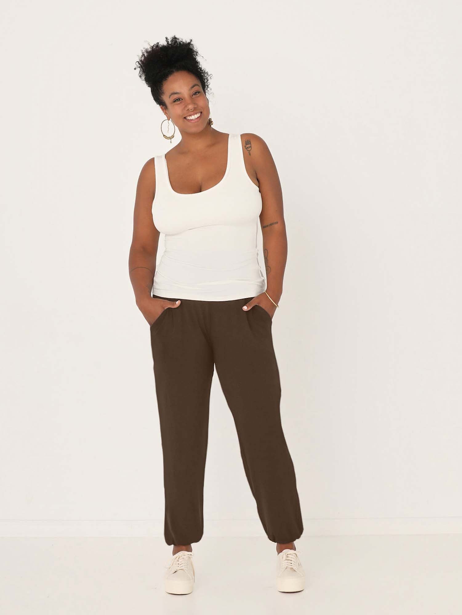 Model wearing cocoa brown lounge pants with a deep waistband, long relaxed leg, elasticised cuff and side pockets, women's bamboo clothing