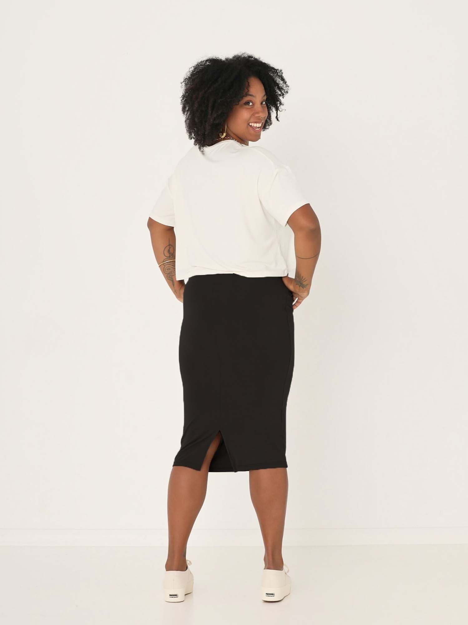 Model wearing black midi pencil tube skirt, mid calf length with a deep waistband, women's bamboo clothing