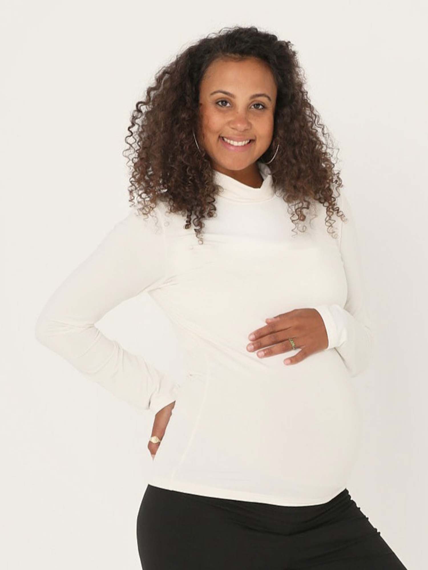 Model wearing cream high roll neck fitted skivvy, fitted long sleeves, women's bamboo clothing