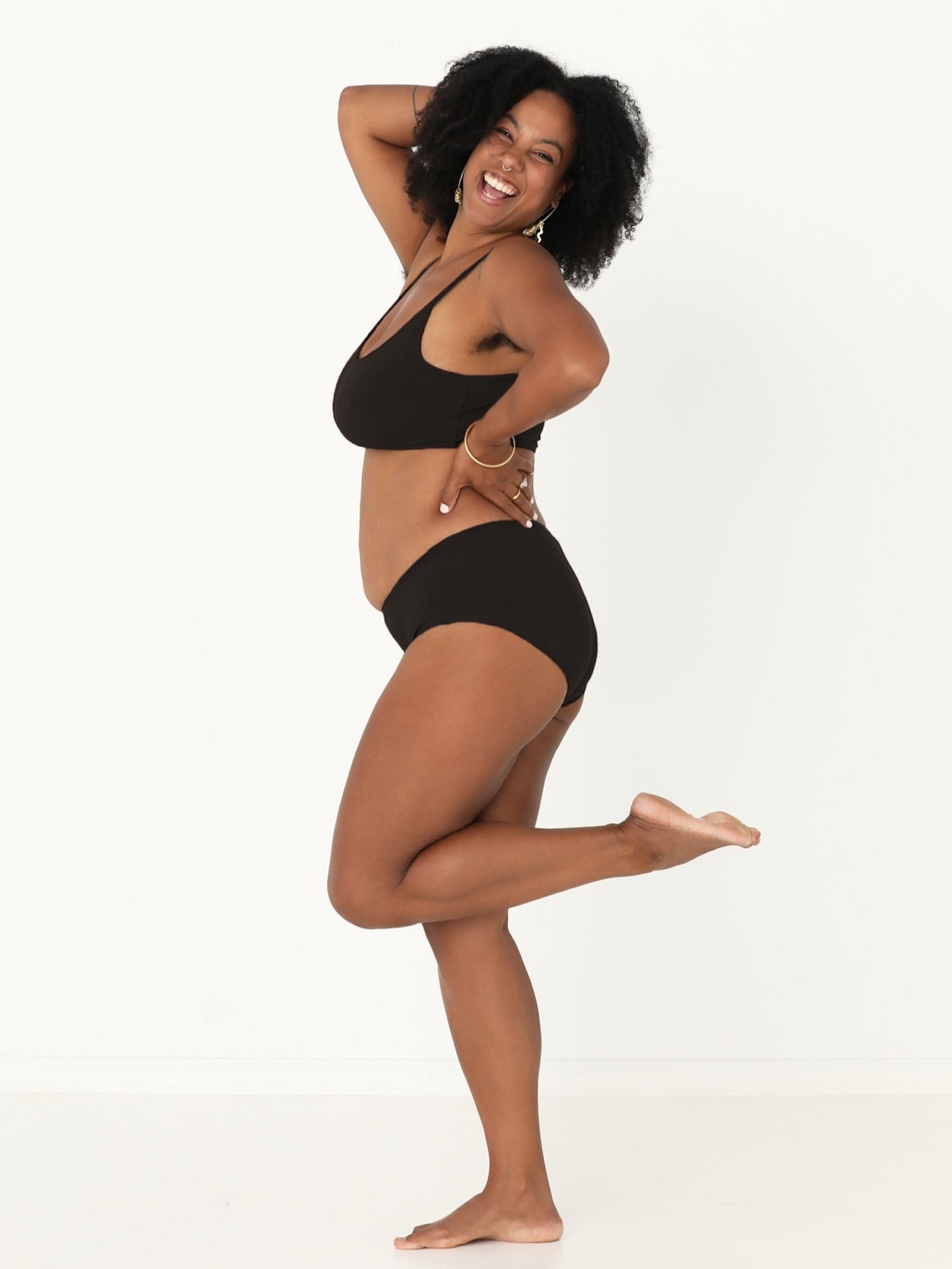 Model wearing a black full brief with mid waist and soft leg banding to lift and shape bottom, women's bamboo underwear