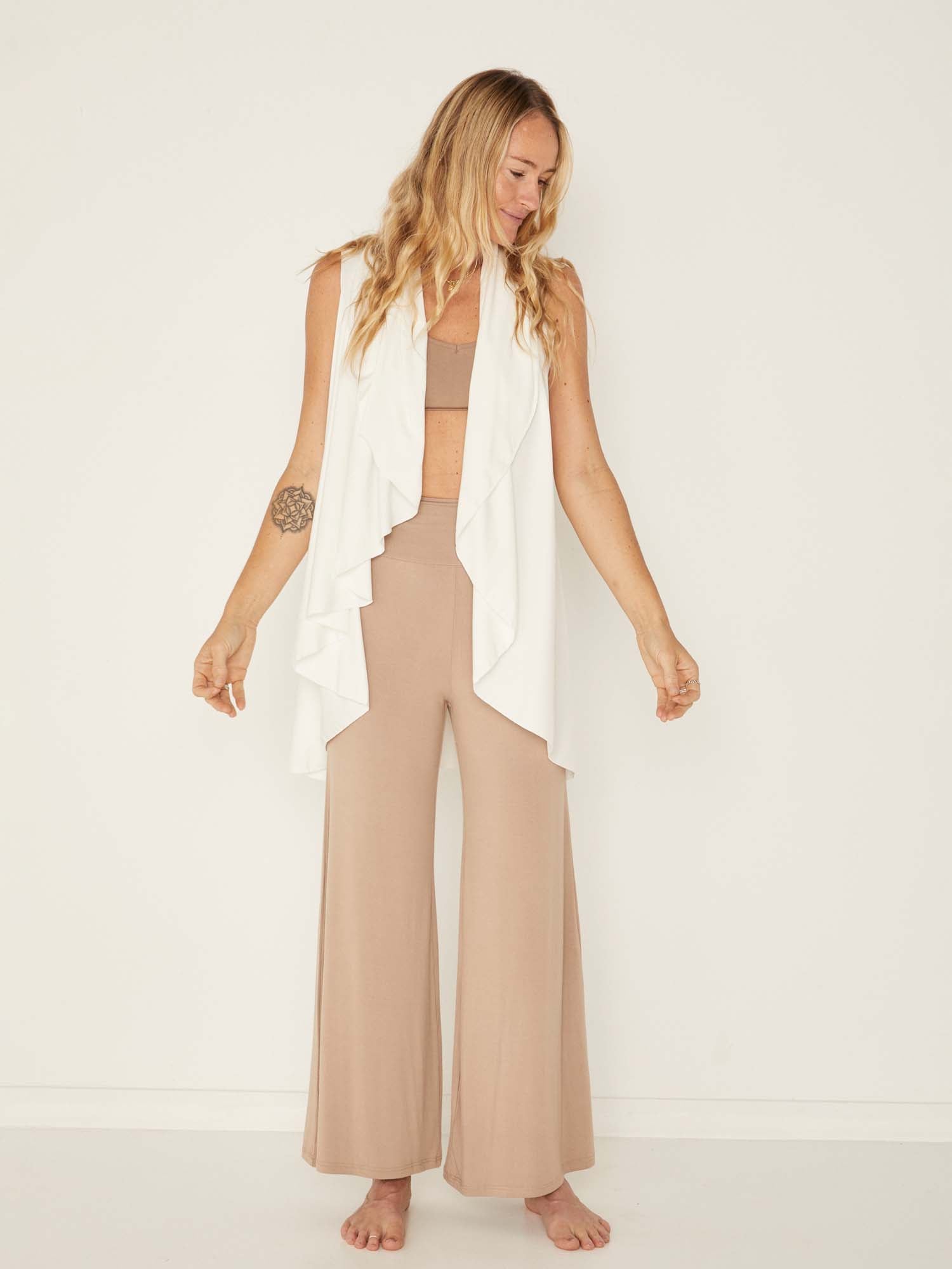 Model wearing a cream convertible style goddess wrap; long cardi, vest or poncho, women's bamboo clothing