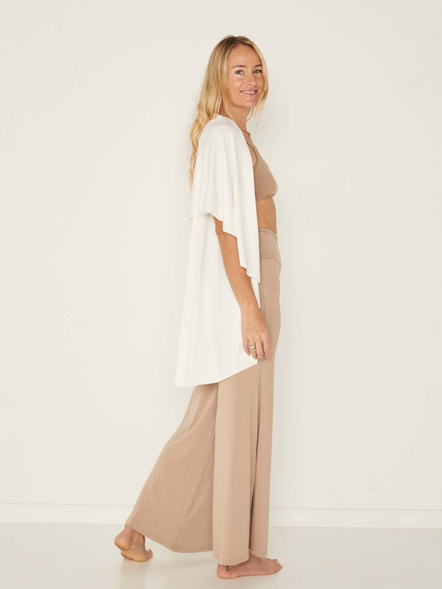 Model wearing a cream convertible style goddess wrap; long cardi, vest or poncho, women's bamboo clothing