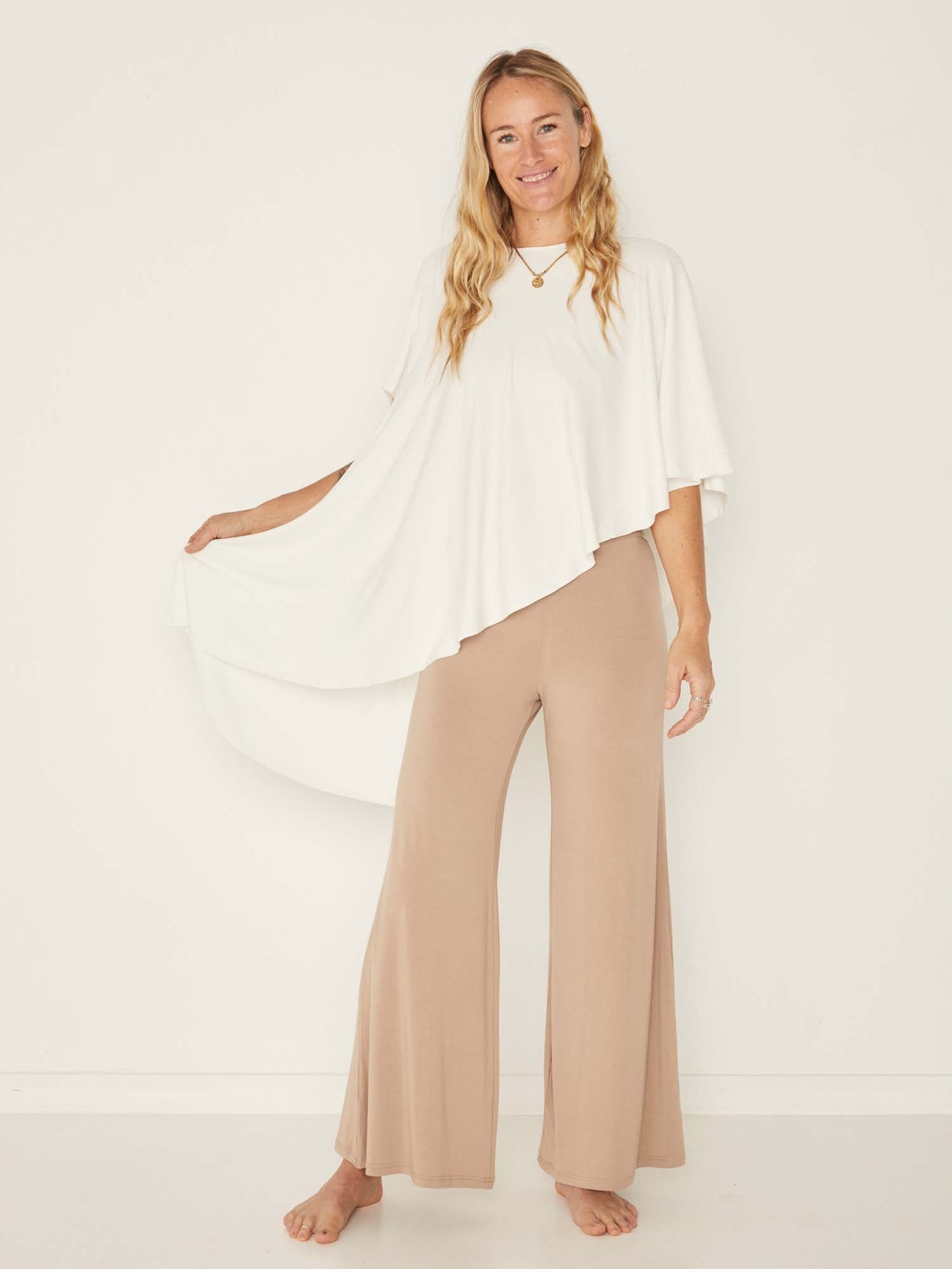 Model wearing a cream convertible style goddess wrap; long cardi, vest or poncho, women's bamboo clothing