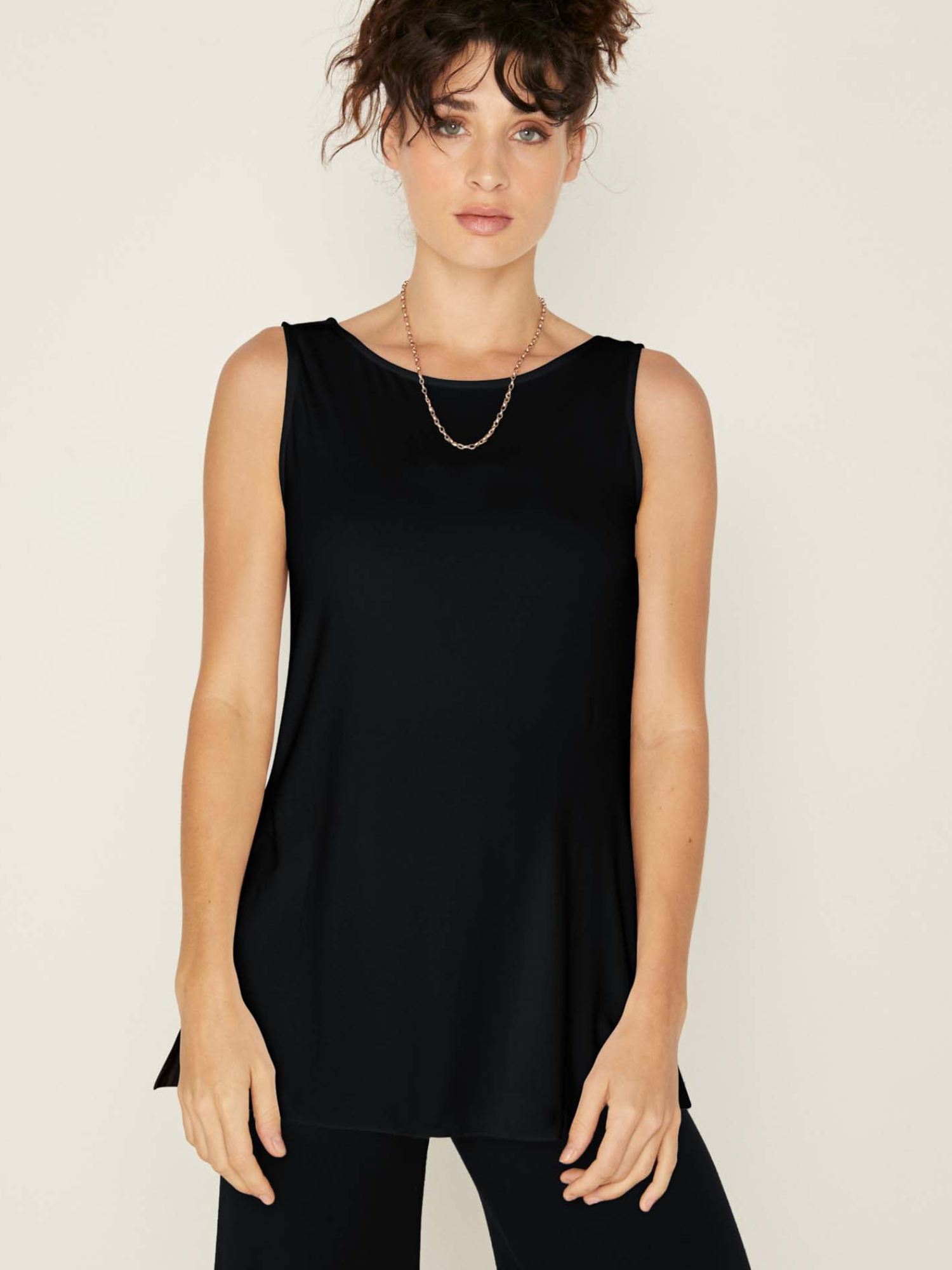Model wearing a reversible black a-line singlet with scoop and boat necklines and long line body, women's bamboo clothing