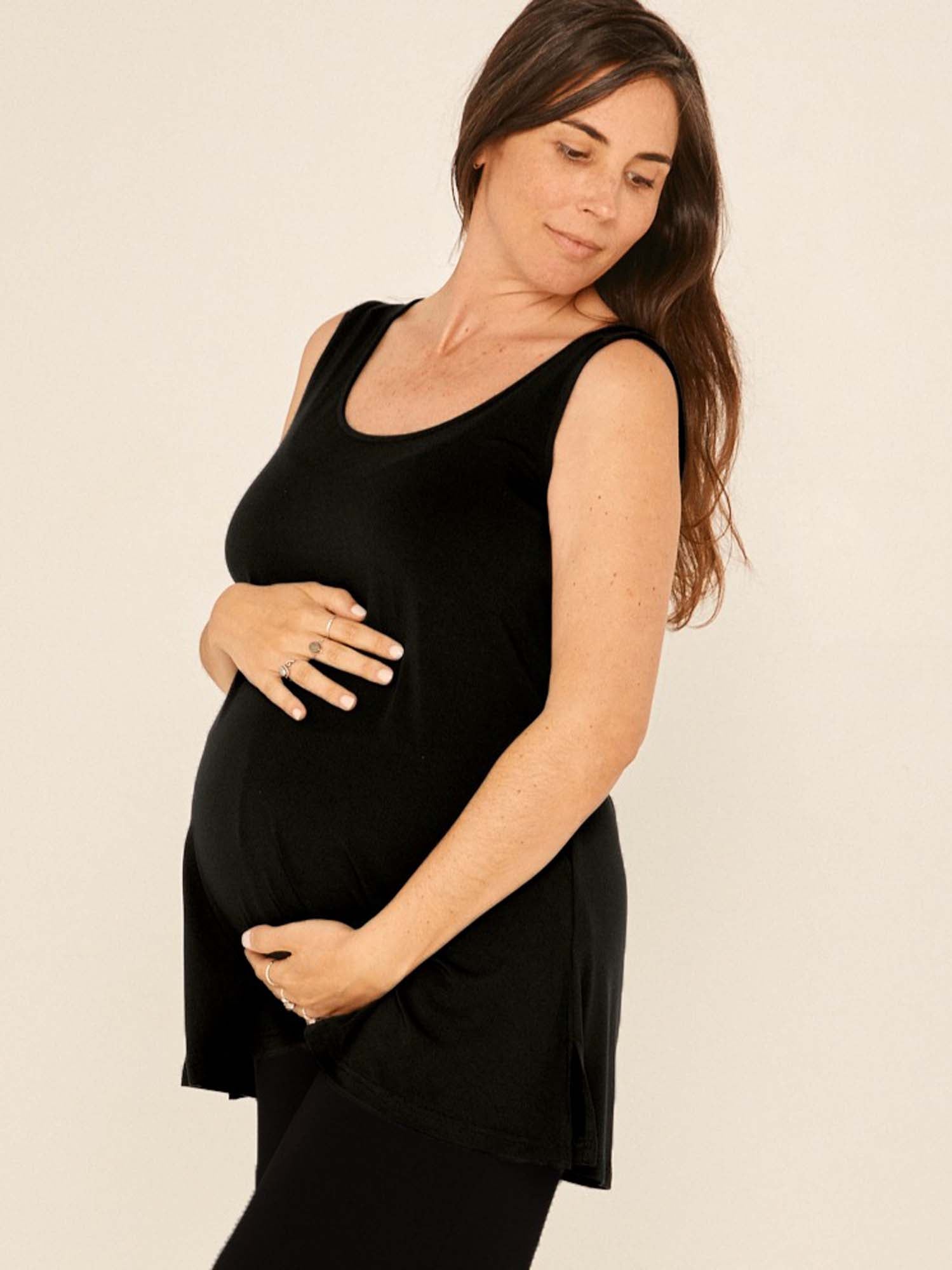Model wearing a reversible black a-line singlet with scoop and boat necklines and long line body, women's bamboo clothing