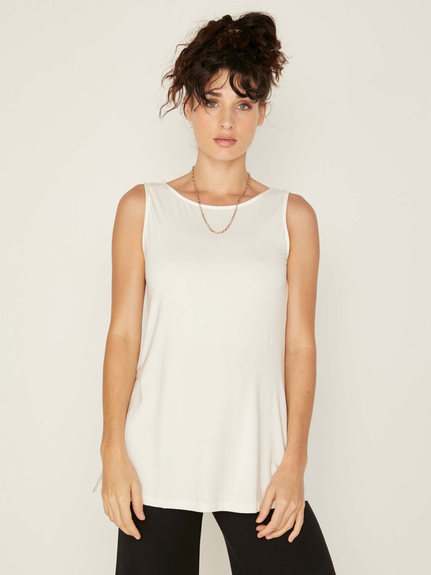 Model wearing a reversible cream a-line singlet with scoop and boat necklines and long line body, women's bamboo clothing