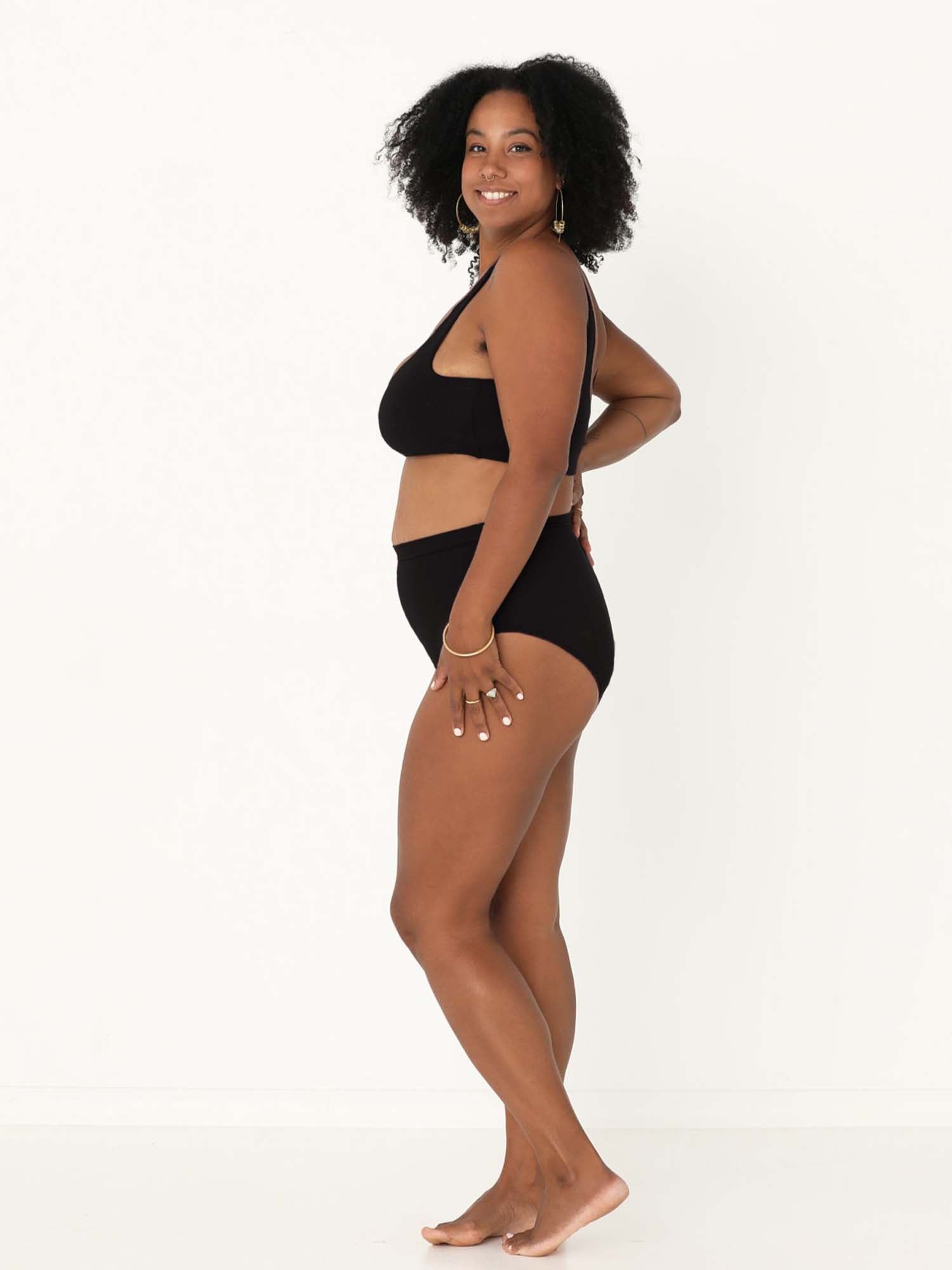 Model wearing black high waisted full brief with mid leg opening and double layered waistband, women's bamboo underwear