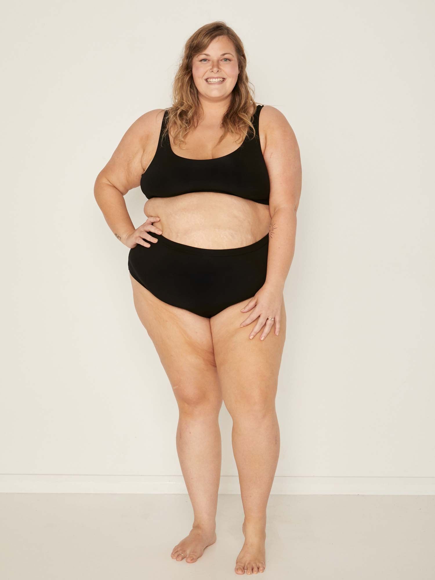 Model wearing black high waisted full brief with mid leg opening and double layered waistband, women's bamboo underwear