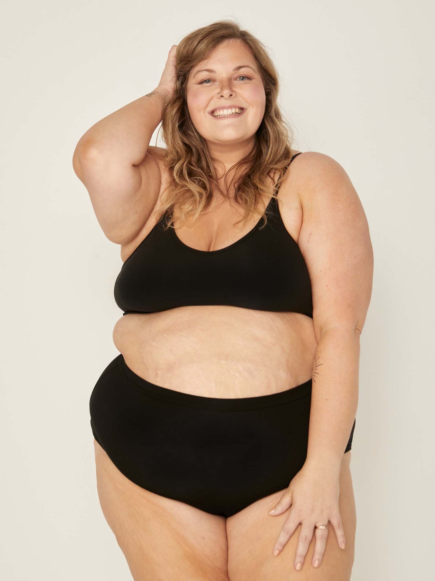 Model wearing black high waisted full brief with mid leg opening and double layered waistband, women's bamboo underwear