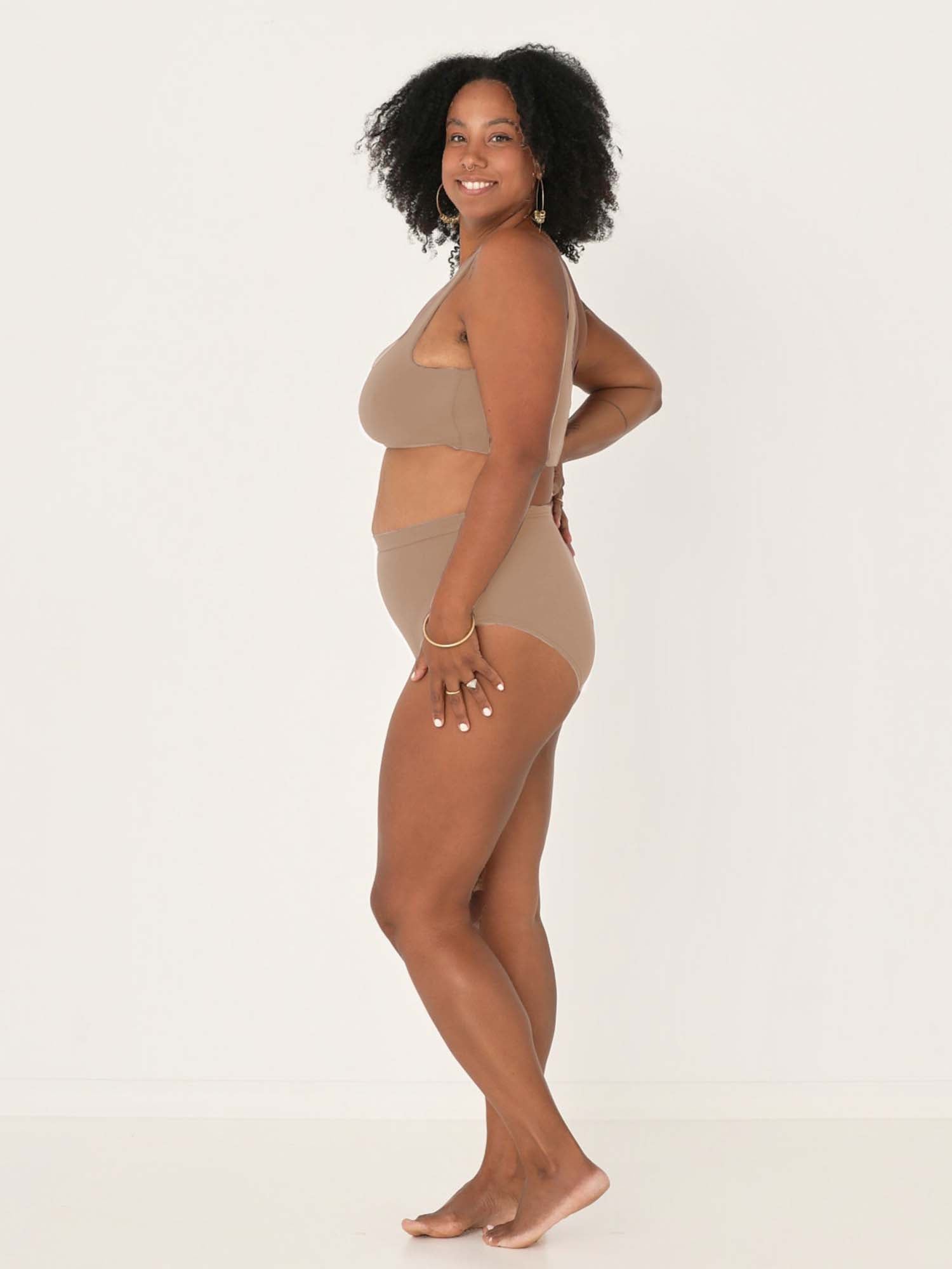 Model wearing caramel high waisted full brief with mid leg opening and double layered waistband, women's bamboo underwear