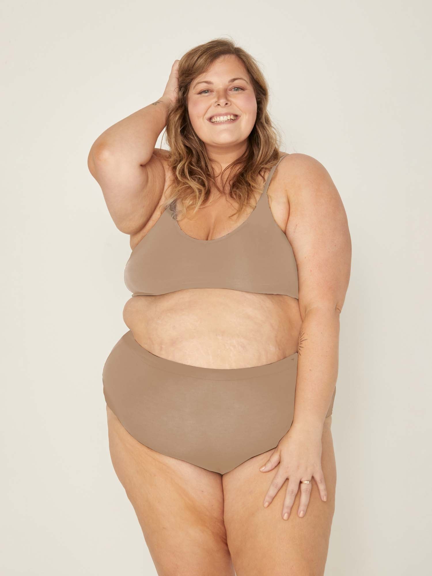 Model wearing caramel high waisted full brief with mid leg opening and double layered waistband, women's bamboo underwear