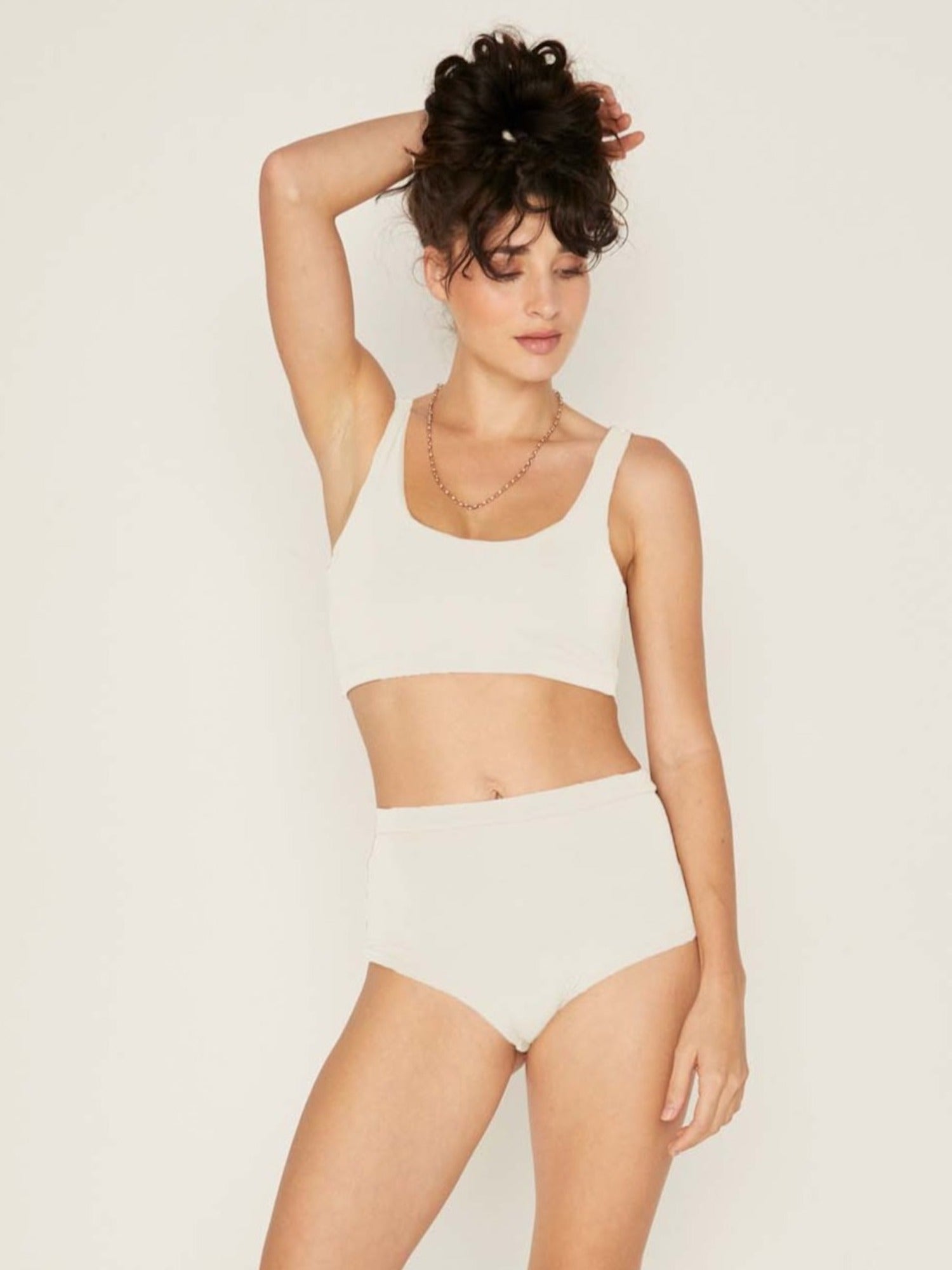 Model wearing cream high waisted full brief with mid leg opening and double layered waistband, women's bamboo underwear