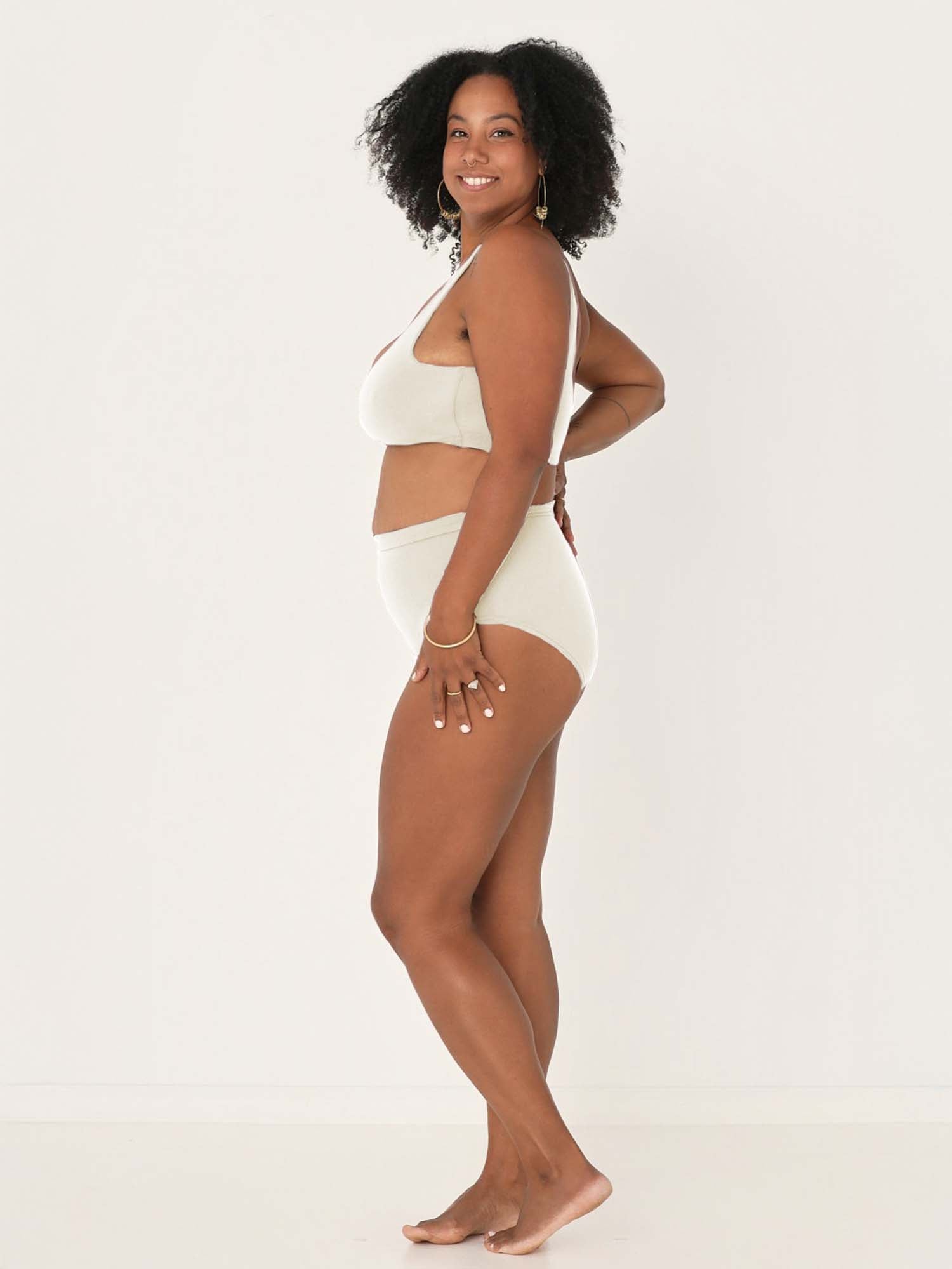 Model wearing cream high waisted full brief with mid leg opening and double layered waistband, women's bamboo underwear