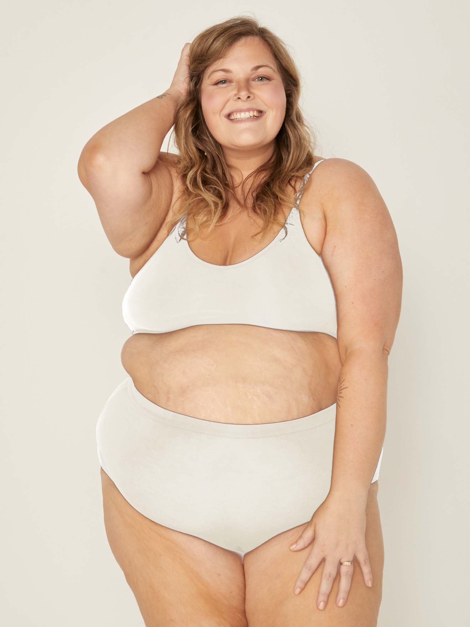 Model wearing cream high waisted full brief with mid leg opening and double layered waistband, women's bamboo underwear