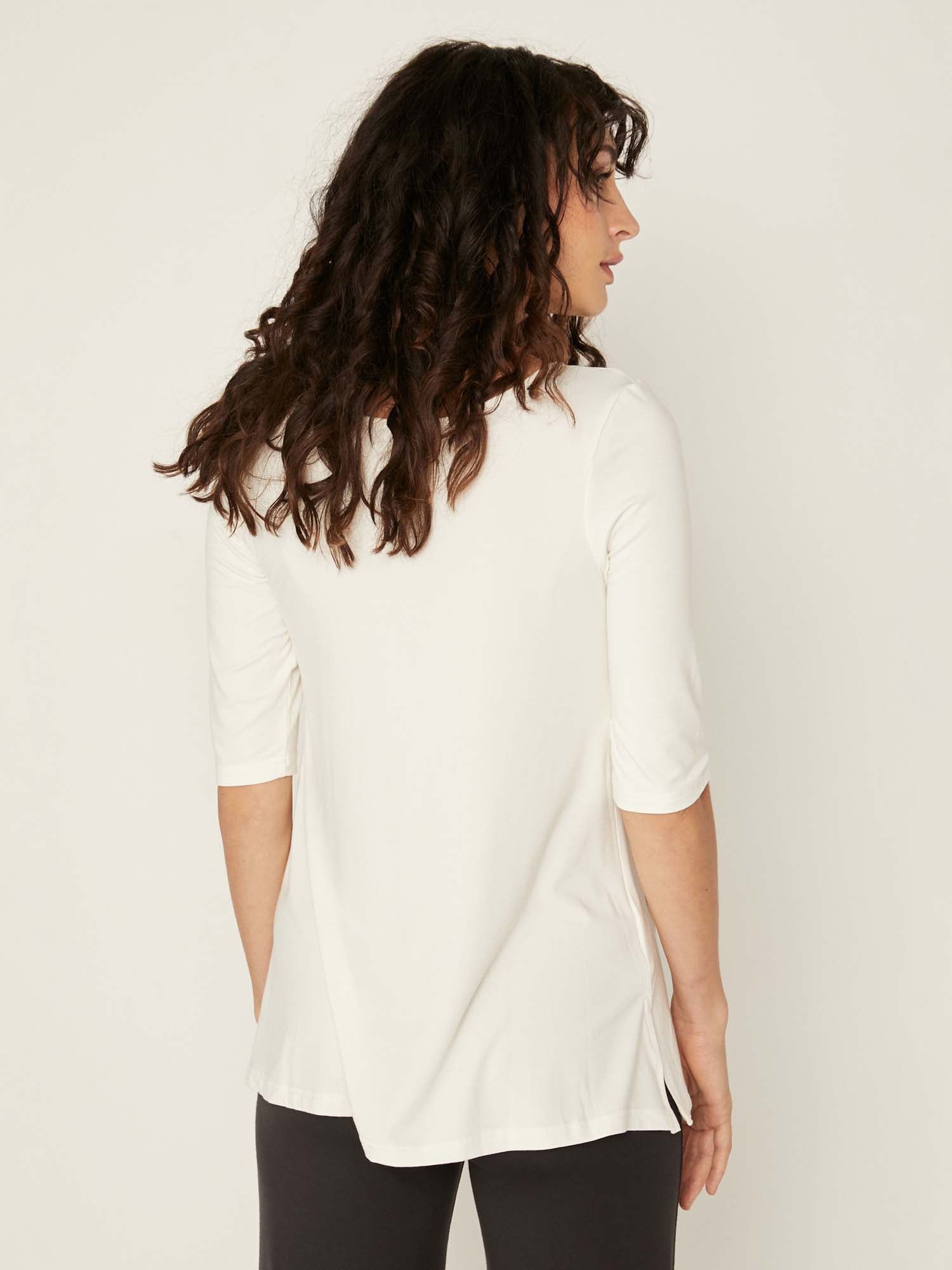 Model wearing a reversible cream mid sleeve t-shirt with scoop and boat necklines, a-line long line body, women's bamboo clothing