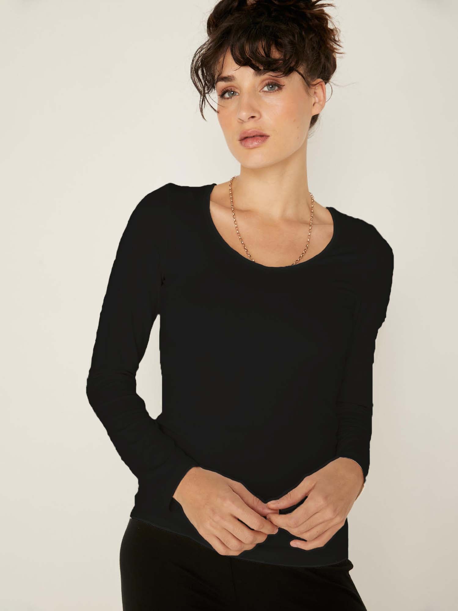 Model wearing a reversible black fitted body, long sleeve t-shirt with v and boat necklines, women's bamboo clothing