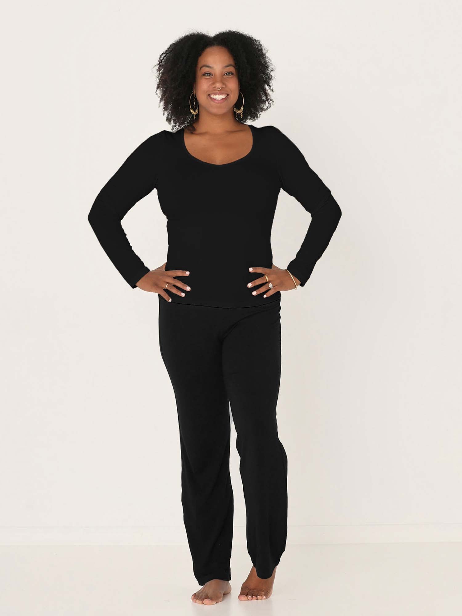 Model wearing a reversible black fitted body, long sleeve t-shirt with v and boat necklines, women's bamboo clothing