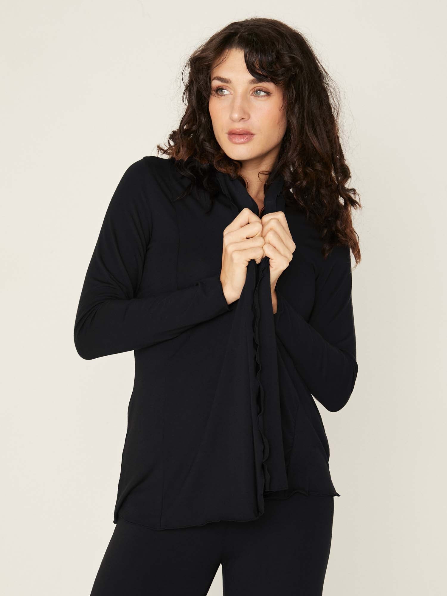 Model wearing convertible black mid cardigan, worn tied at front or worn open with long fitted sleeves, women's bamboo clothing