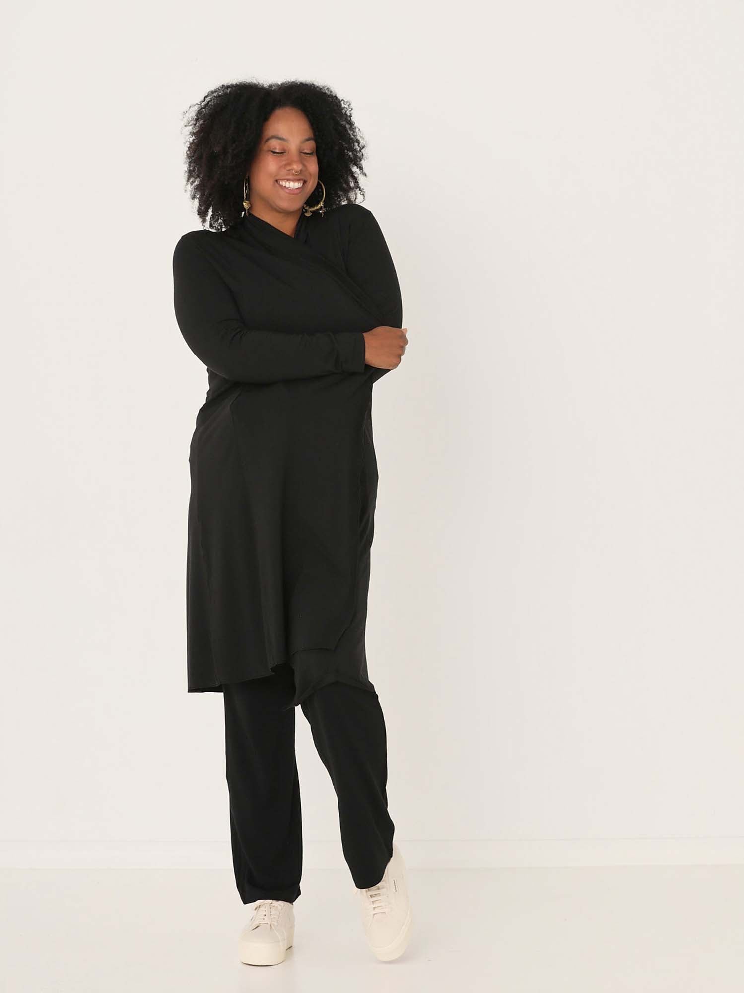 Model wearing black long cardigan, below knee length jacket with long fitted sleeves, women's bamboo clothing